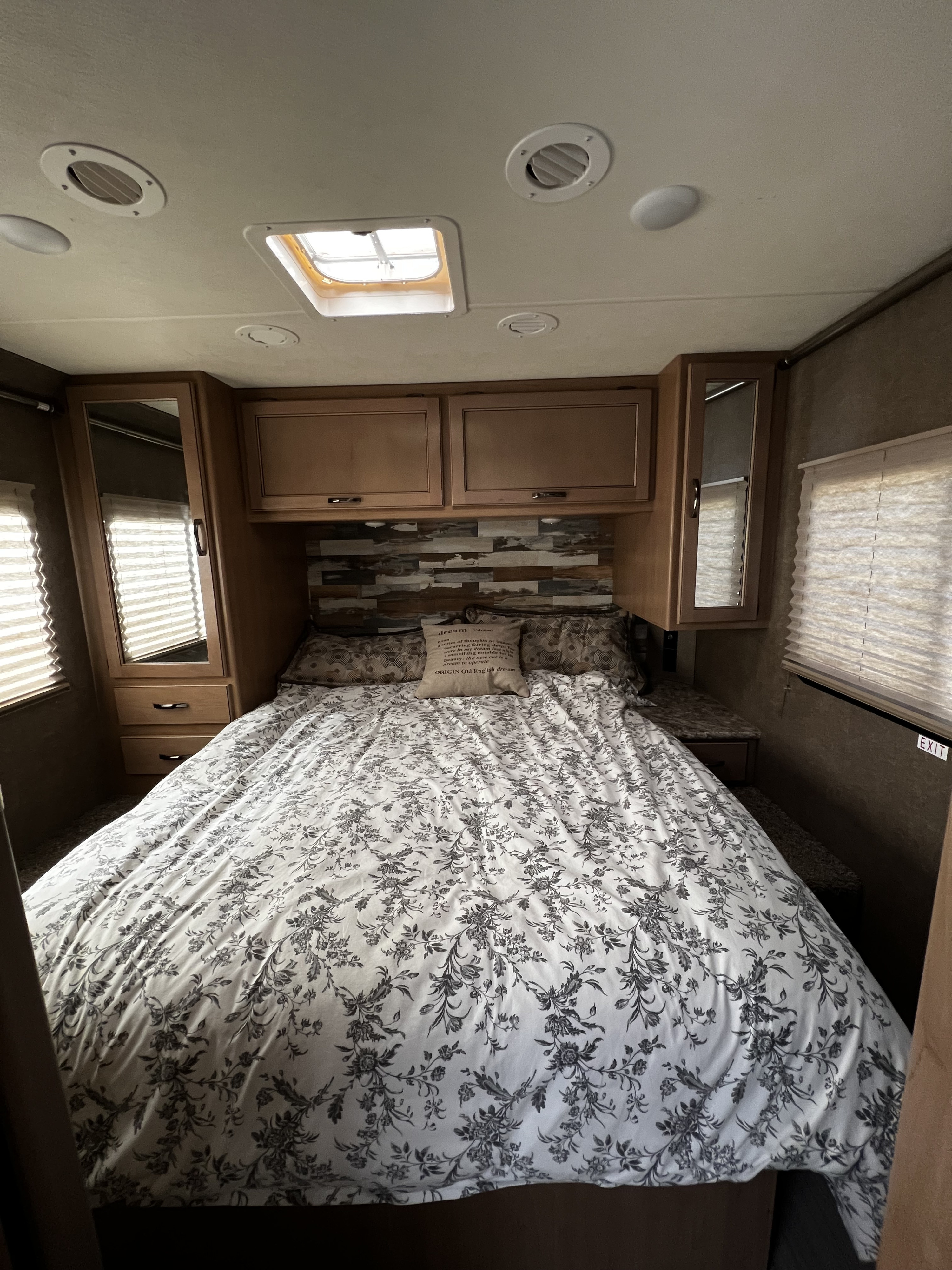 RV rental bedroom: Cozy bed with floral bedding, overhead cabinets, and climate vents ensure comfort on the road.. Thor Quantum SE 2020