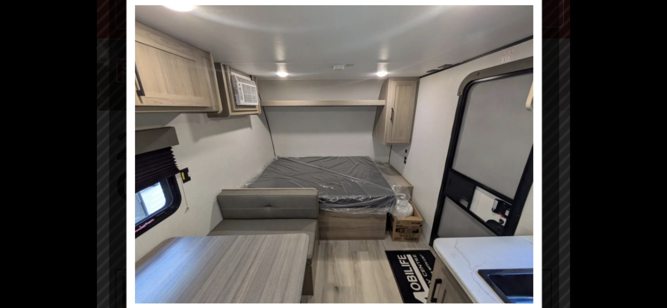 Interior of an rv rental featuring a dinette, bed, overhead cabinets, and a countertop with sink. Ideal for camping trips.. Coleman 17b 2025