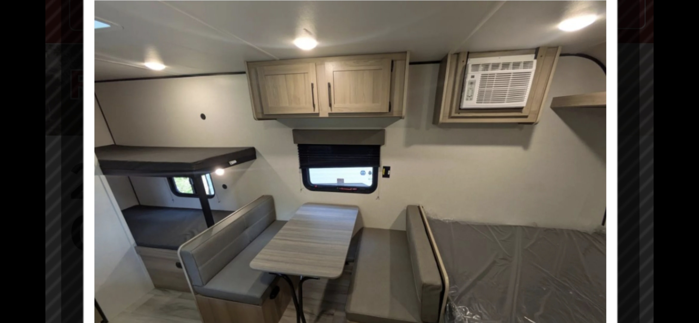 RV rental interior: This camper features bunk beds (left), a central dinette, and a high-mounted AC unit (right).. Coleman 17b 2025