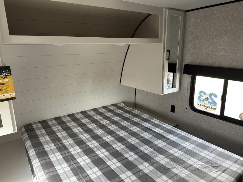 Comfortable RV rental bedroom with a plaid bed, overhead storage, and window. Perfect for your next adventure.. Jayco Jay Flight 2026