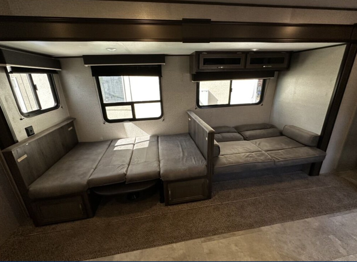 RV rental interior: two grey convertible dinette/sofa beds, offering flexible sleeping arrangements with windows.. Jayco Jay Flight 2020