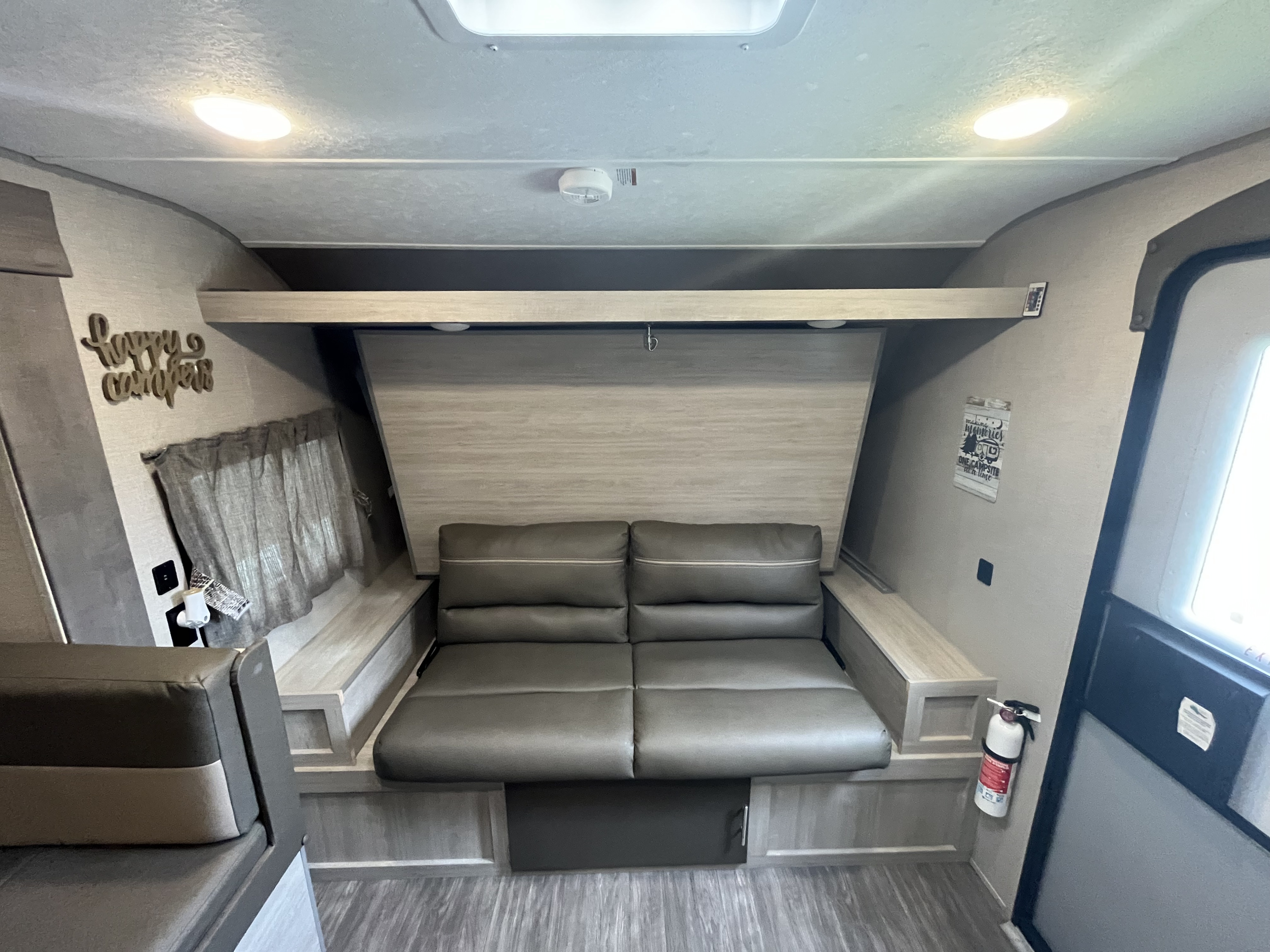 Step into this RV rental, showcasing a comfortable convertible sofa, overhead bunk bed, and bright, modern interior.. Forest River Aurora Aurora 2022