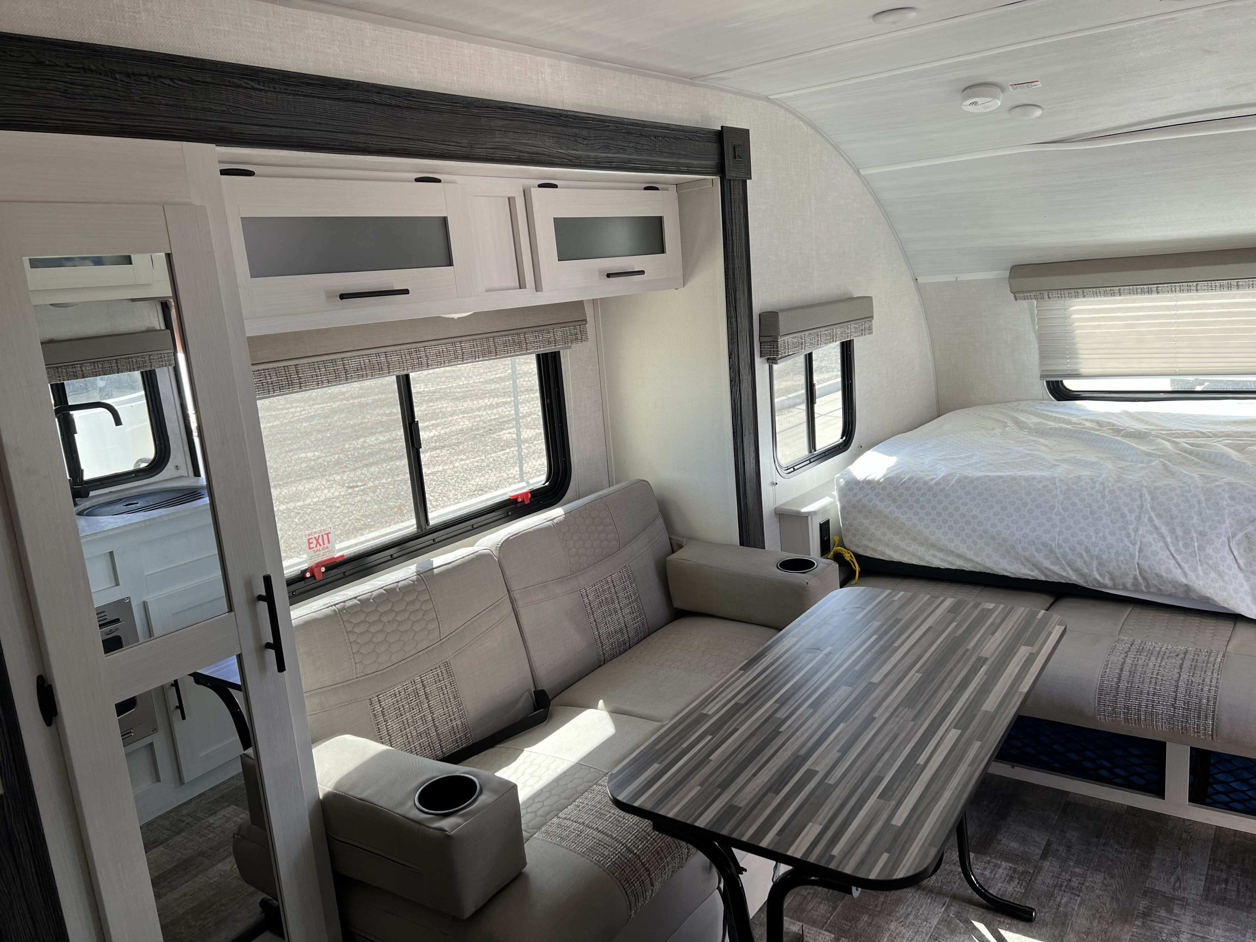 Modern RV rental interior: sofa, dining table, and bed area, offering comfortable travel living.. Forest River R-Pod 2021