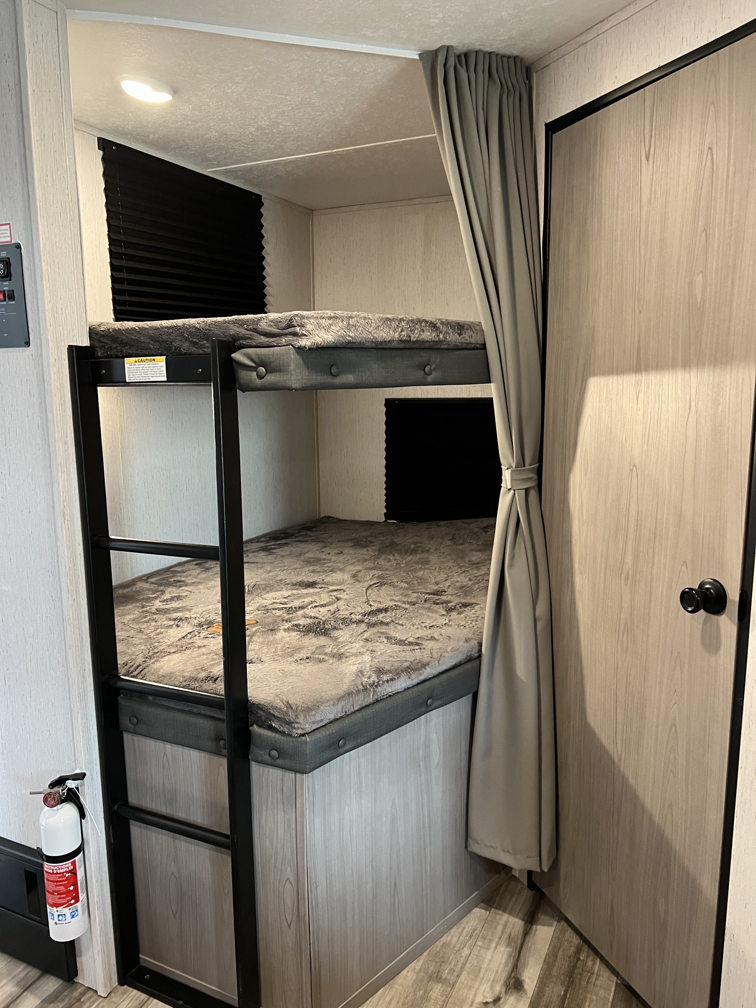 Comfortable bunk beds, complete with a ladder, privacy curtain, and fire extinguisher, for your next RV rental adventure.. Dutchmen Coleman Lantern 2022