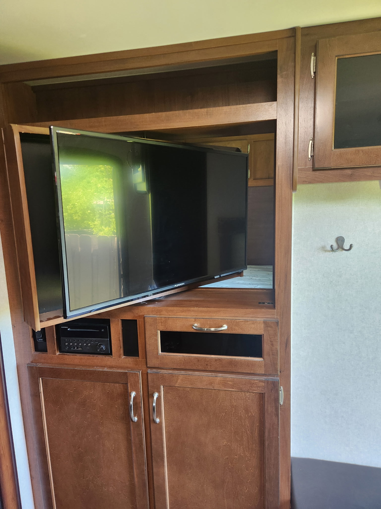This RV rental's living area showcases a swiveling Furrion TV and integrated entertainment system within elegant wood cabinetry.. Jayco Jay Flight 2017
