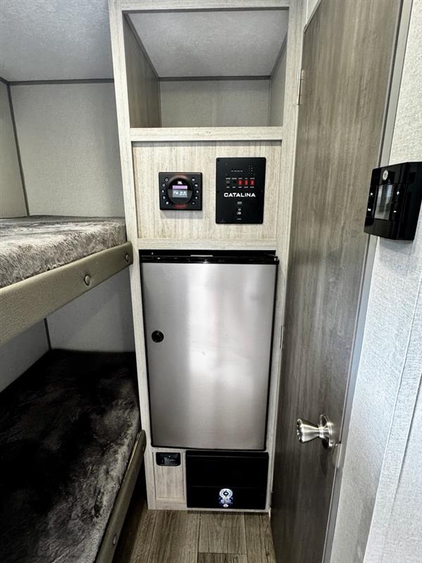 RV rental interior features bunk beds, a mini-fridge, and integrated control panels for compact living.. Forest River Coachmen Catalina 134BHX 2025