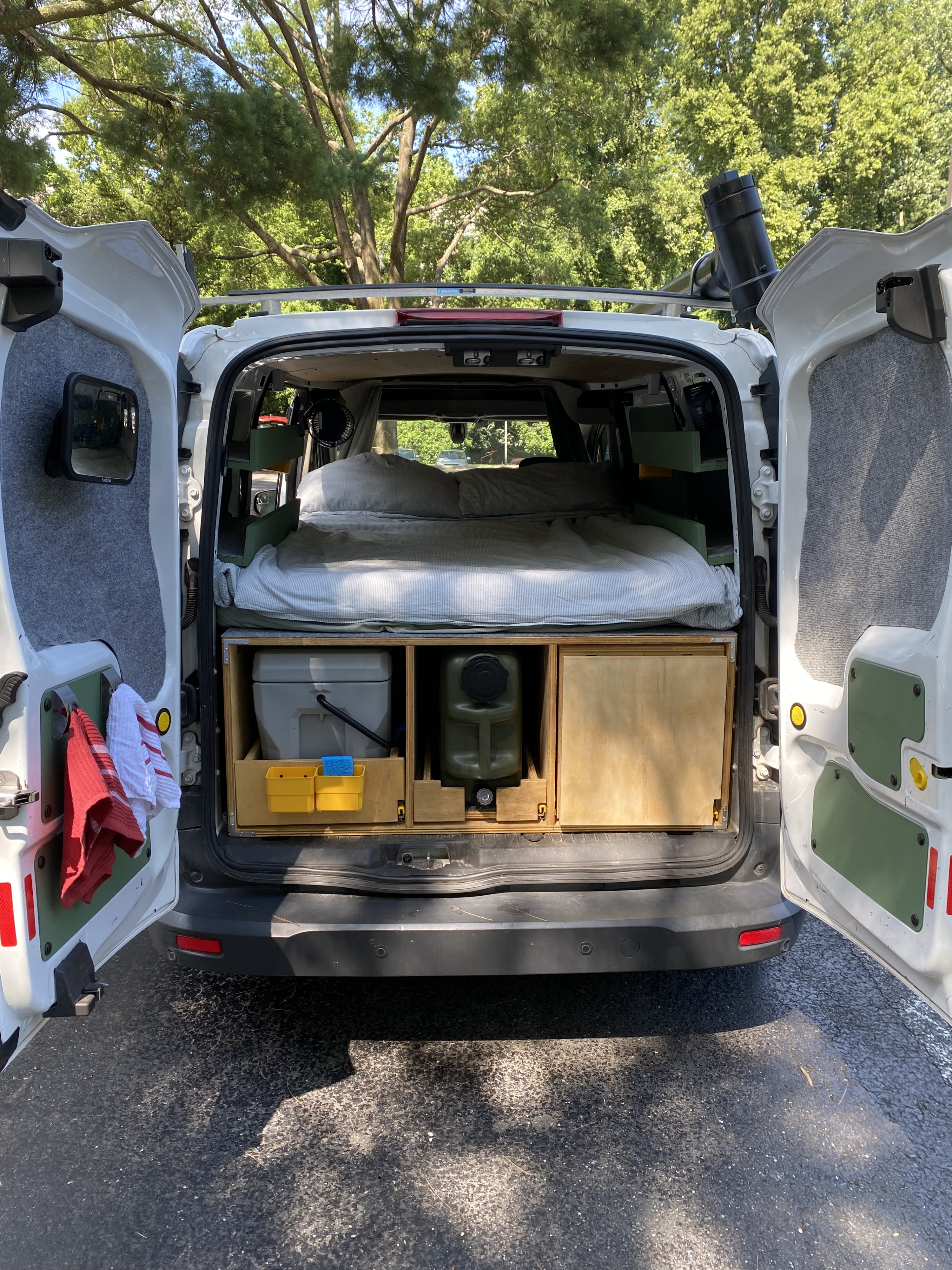 This cozy camper van conversion, perfect for an RV rental, shows its bed, toilet, and water setup, ready for adventure.. Ford Custom Transit 2017