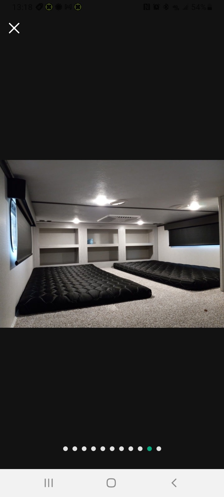 Spacious RV rental bunk room. Two black mattresses on carpet, built-in shelves, and window blinds. Clean, modern interior.. Keystone RV Montana High Country 2021