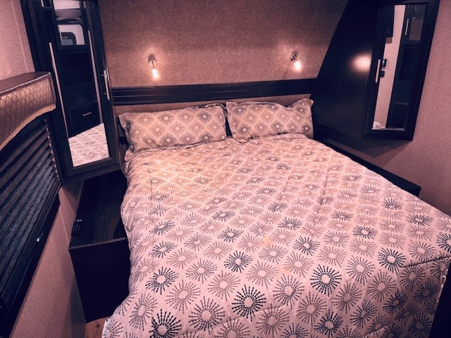 Step into comfort: This RV rental bedroom features a cozy bed with patterned bedding and built-in storage.. Jayco Eagle HT 2019