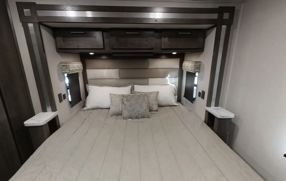 This comfortable RV rental bedroom features a queen bed with a padded headboard, overhead storage, and built-in nightstands.. Forest River gt5 2021