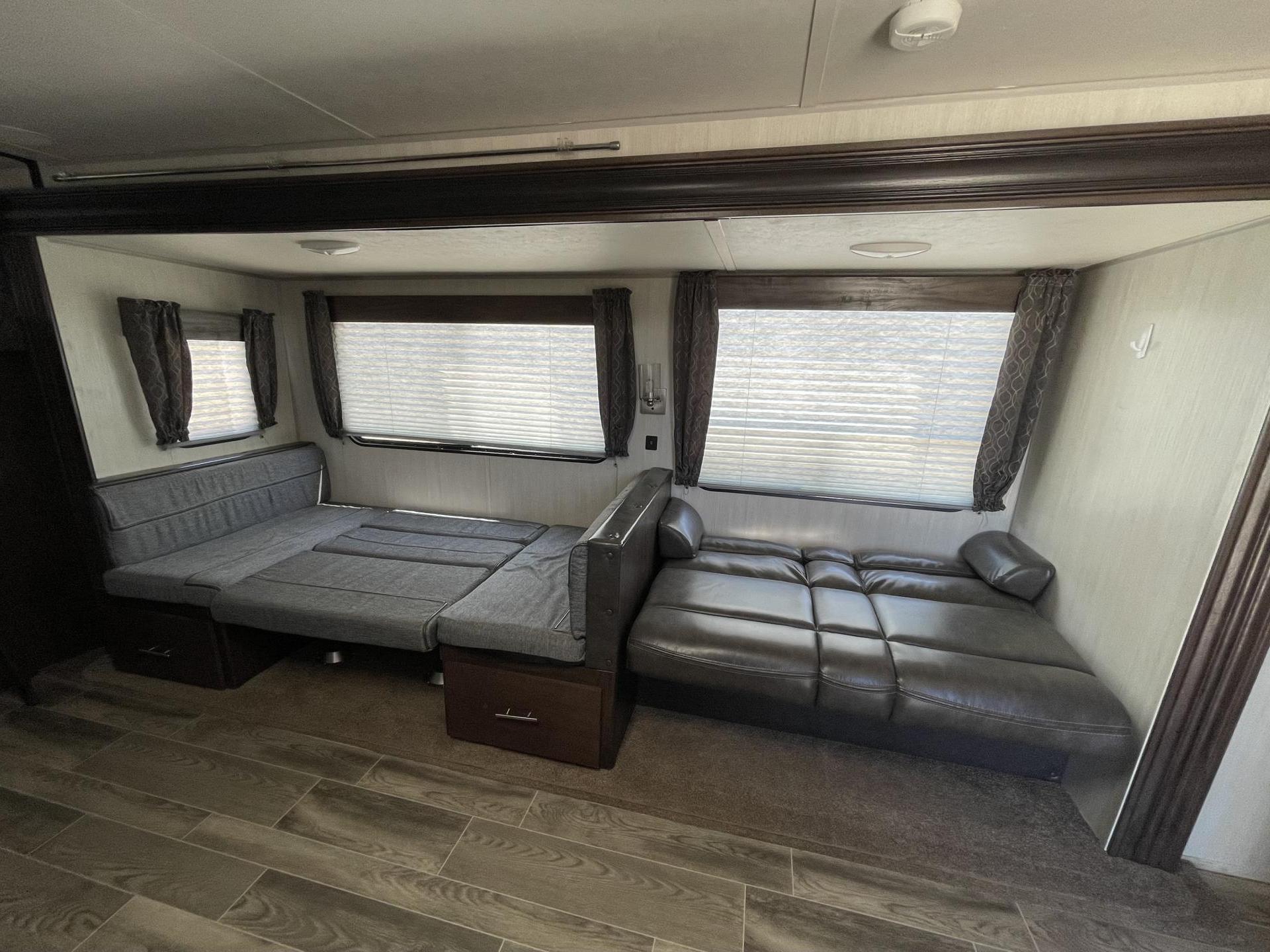 RV rental interior: fabric and leather convertible sofas provide versatile seating and bed options.. Forest River Cherokee 2019