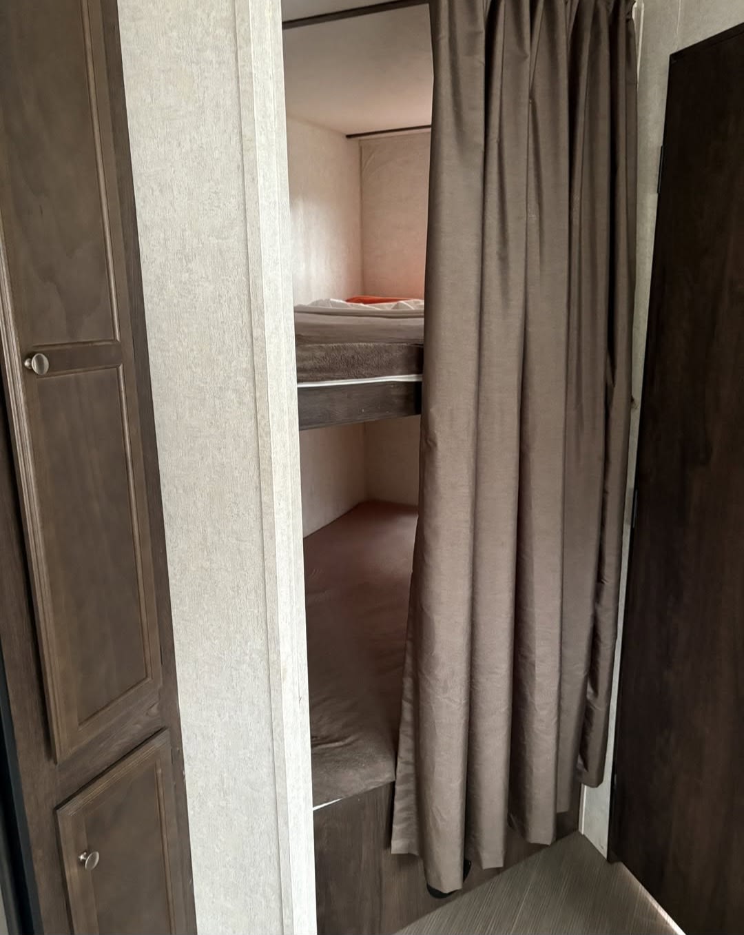Inside an RV rental: bunk beds with a privacy curtain & storage, offering cozy sleeping in a travel trailer.. Starcraft GPS 2018