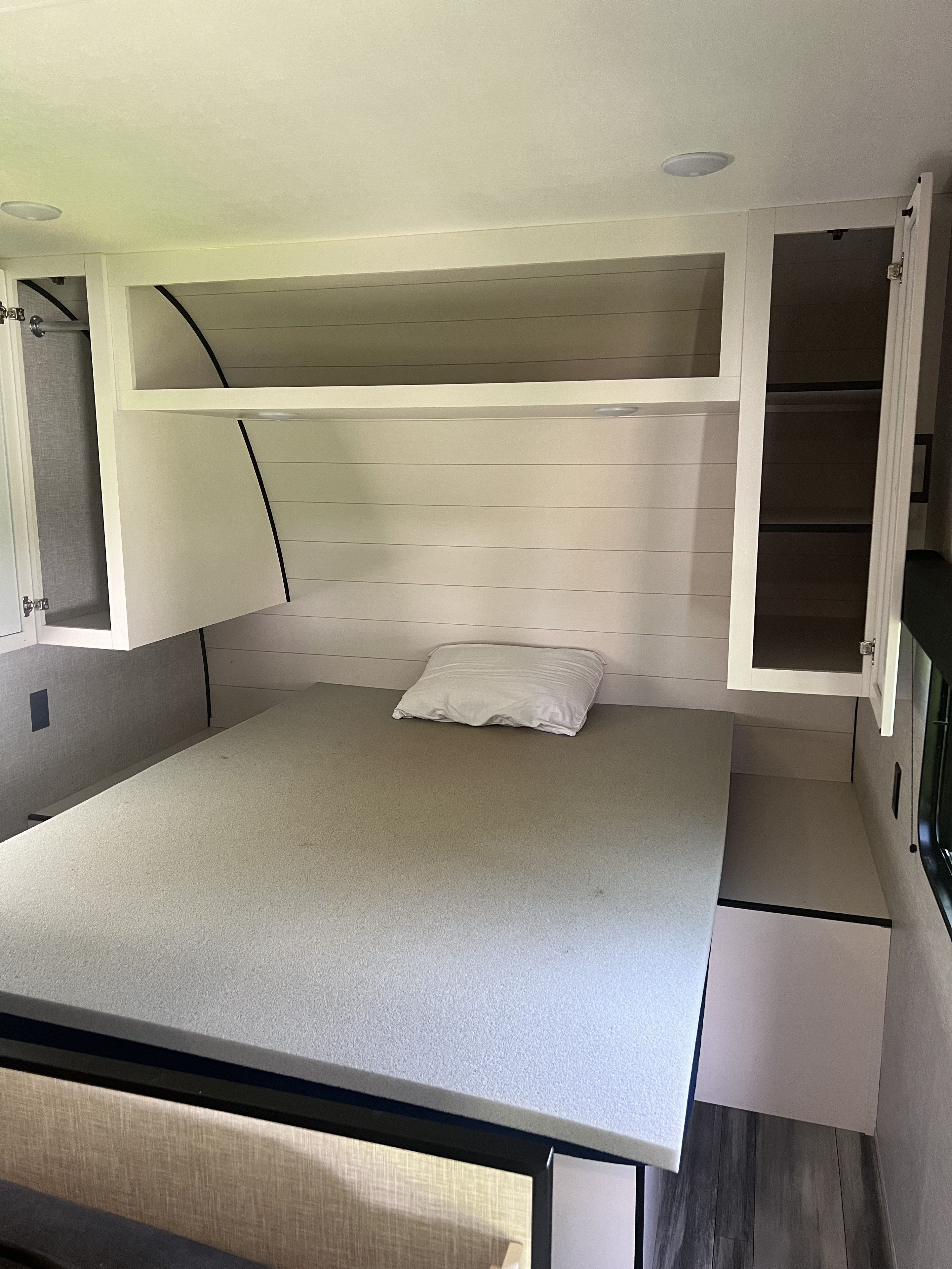 This RV rental bedroom features a foam mattress bed, white overhead cabinetry, shiplap wall, and wood-look flooring.. Jayco Jay Flight SLX 260BH 2025