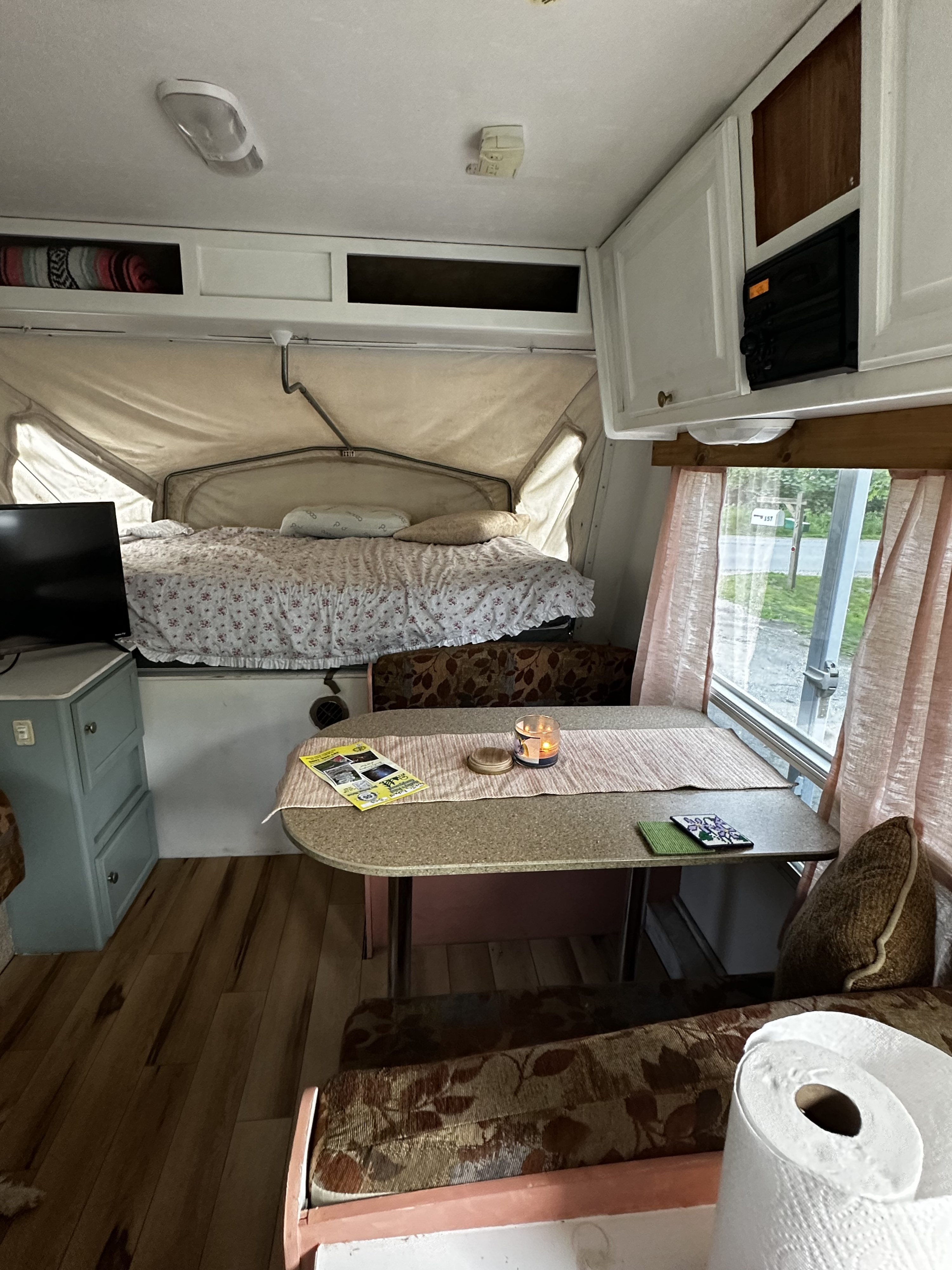 Pop-up RV rental interior with a bed, dining space, & kitchen area, ready for adventures.. Jayco Jay Flight 2008