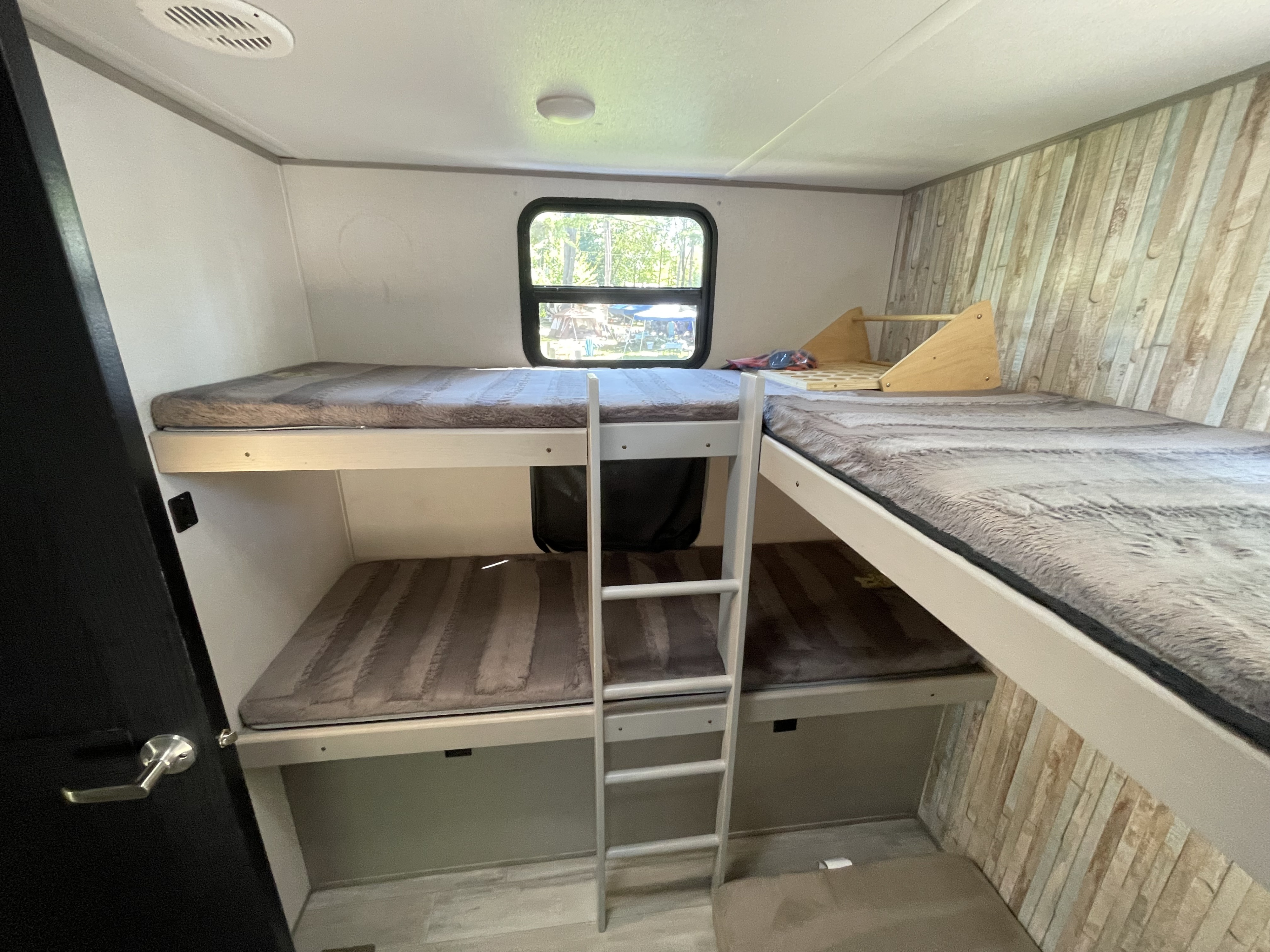 Inside an RV rental: comfortable bunk beds with fuzzy mattresses & a ladder. Perfect for family camper trips.. Forest River Tracer 2021