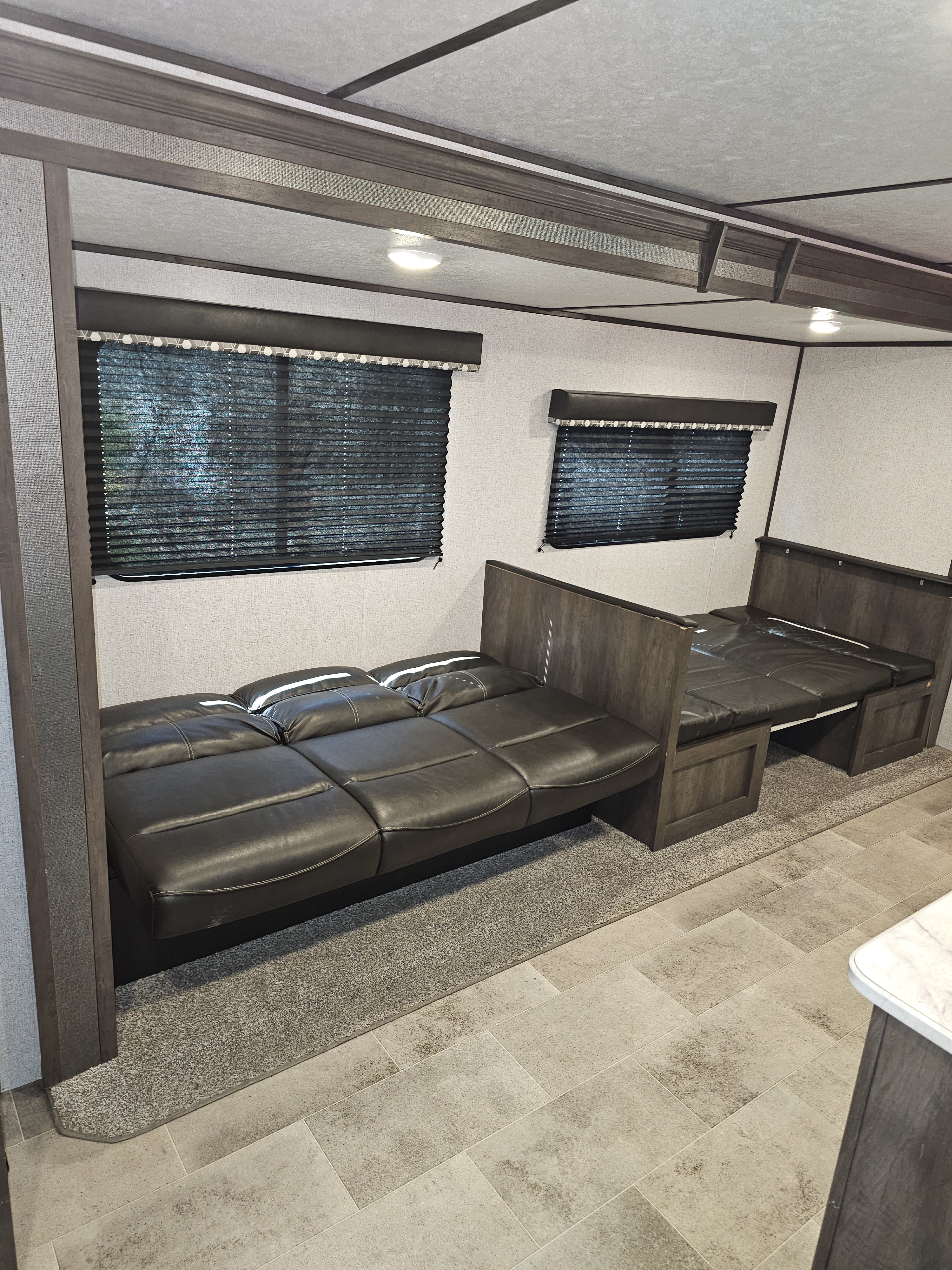 Spacious RV rental interior with convertible sofas/beds, blinds, and modern finishes, perfect for travel comfort.. Dutchmen Coleman Lantern 2021