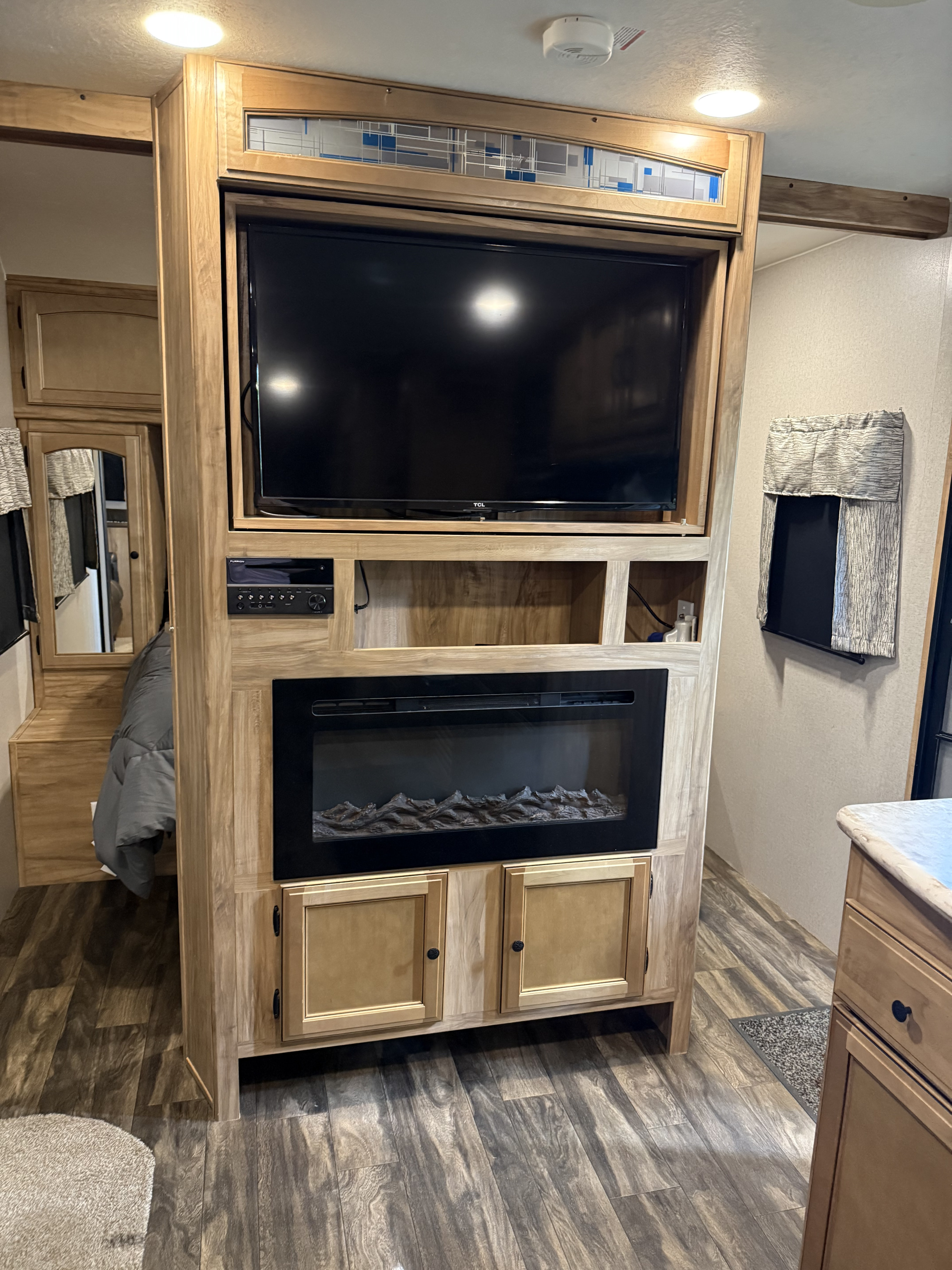 Explore this RV rental's cozy interior, featuring an entertainment center with TV, electric fireplace, and a connected bedroom. Great for trips!. Coachmen Freedom Liberty Express 2019
