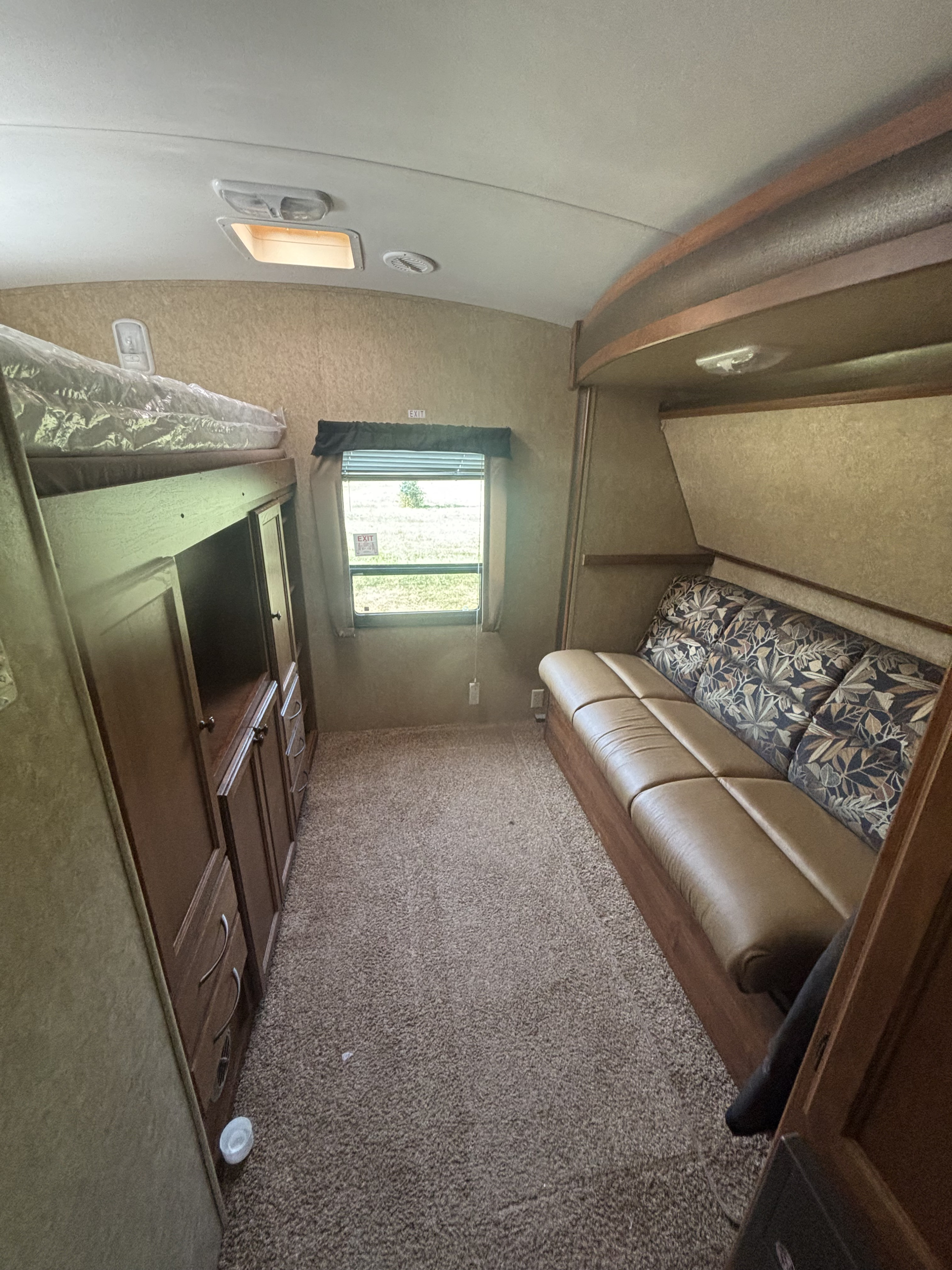RV rental: Interior view with bunk beds, a comfortable sofa, wooden storage, and a bright window to the outdoors.. Heartland RVs Wilderness 2012