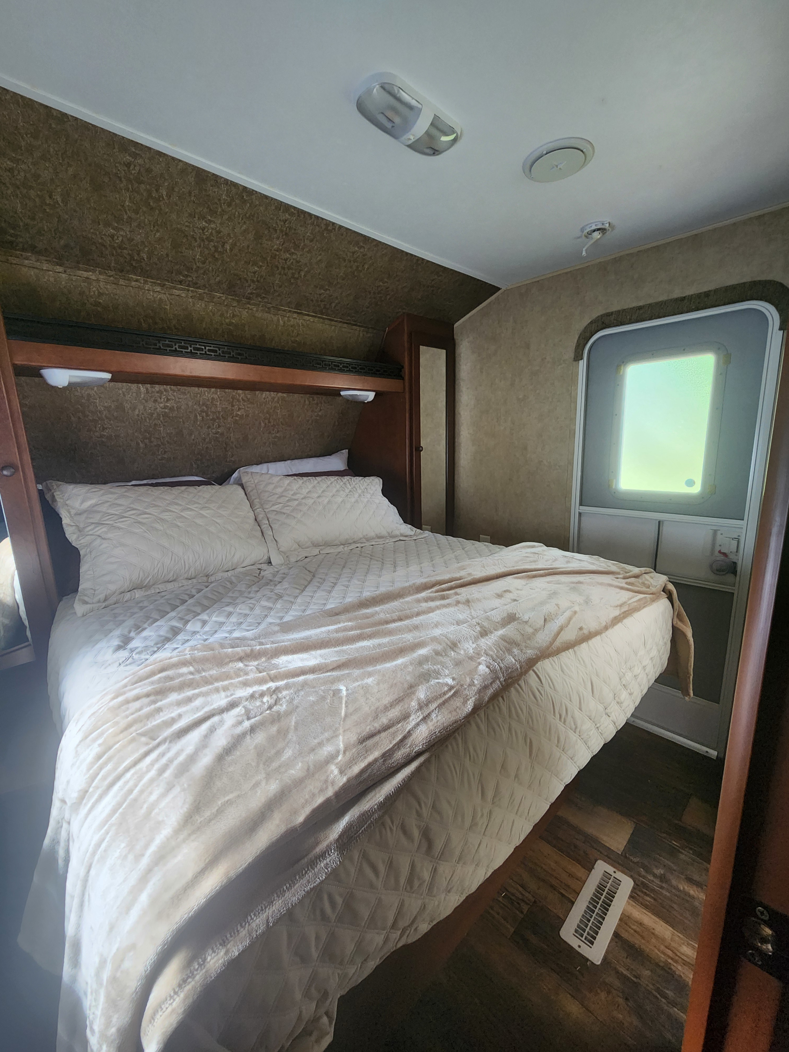 Experience comfort in this inviting RV rental bedroom featuring soft bedding, a compact design, and smart storage.. Aspen Trail Aspen Trail Trailer 2013