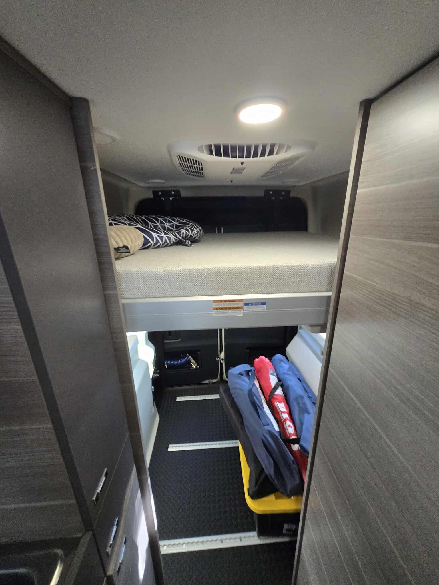 This RV rental's spacious interior features a comfortable upper bunk bed & ample lower storage, perfect for travel adventures.. Entegra Launch Sprinter High Roof AWD 4x4 Camper Van 2025