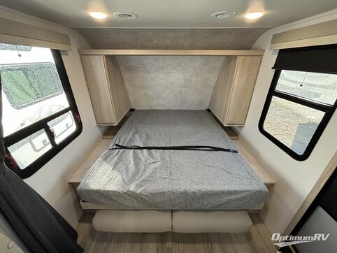 Explore comfort in this RV rental's cozy bedroom. Features a neatly made bed, overhead storage, and windows for light.. Winnebago Micro Mini 2021