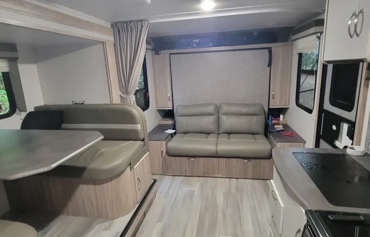 RV rental interior: living area with dinette, convertible sofa, and part of the kitchen counter.. Winnebago Micro Mini 2021