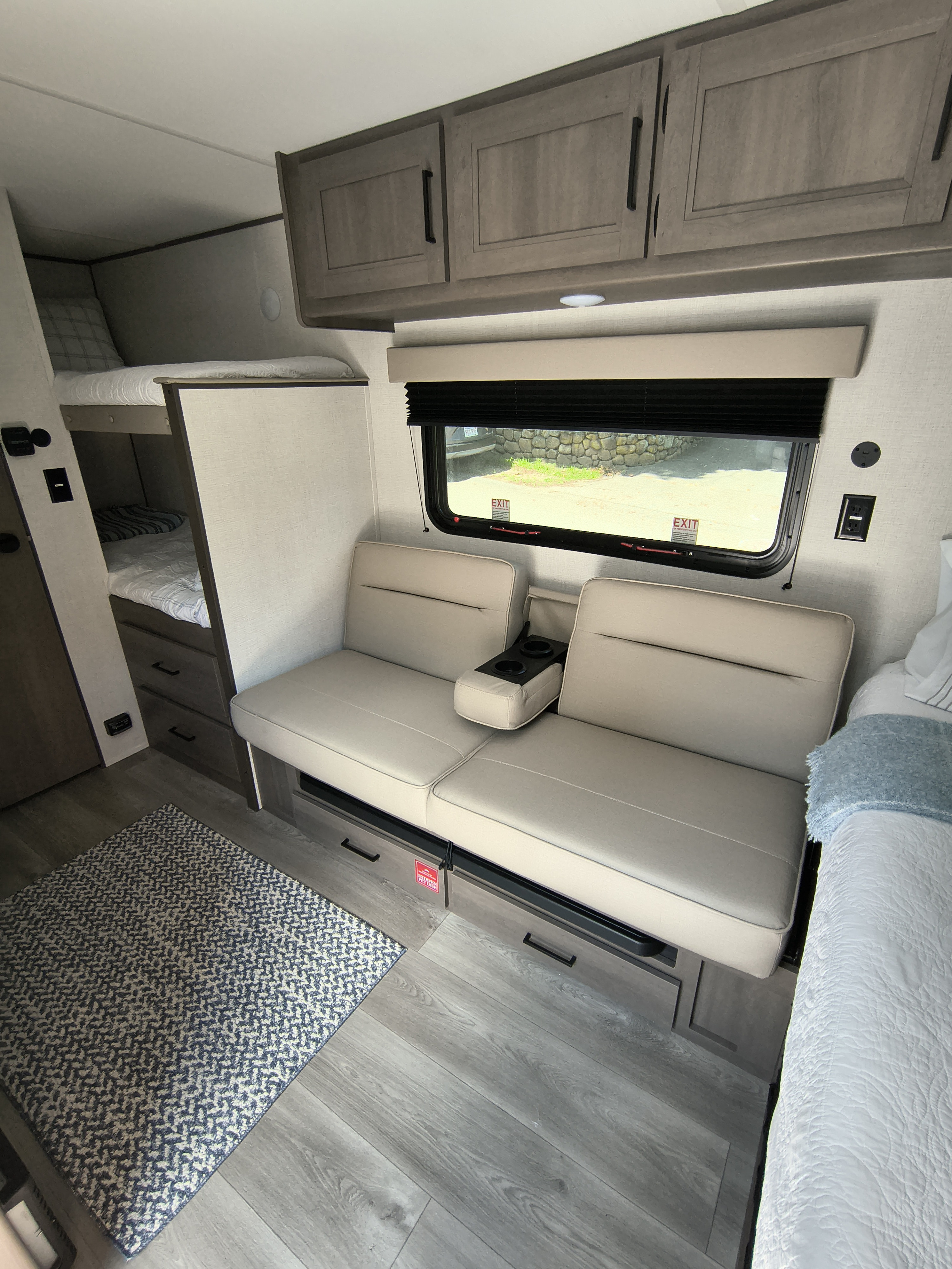 This RV rental interior features modern bunk beds, comfortable seating, and smart storage, perfect for a cozy camper experience.. Grand Design Transcend One 151BH 2026