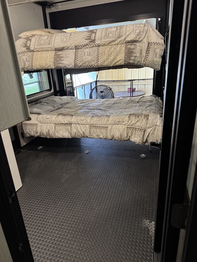 This RV rental interior showcases cozy bunk beds over a durable cargo floor, ideal for adventurers.. Heartland Cyclone 2022