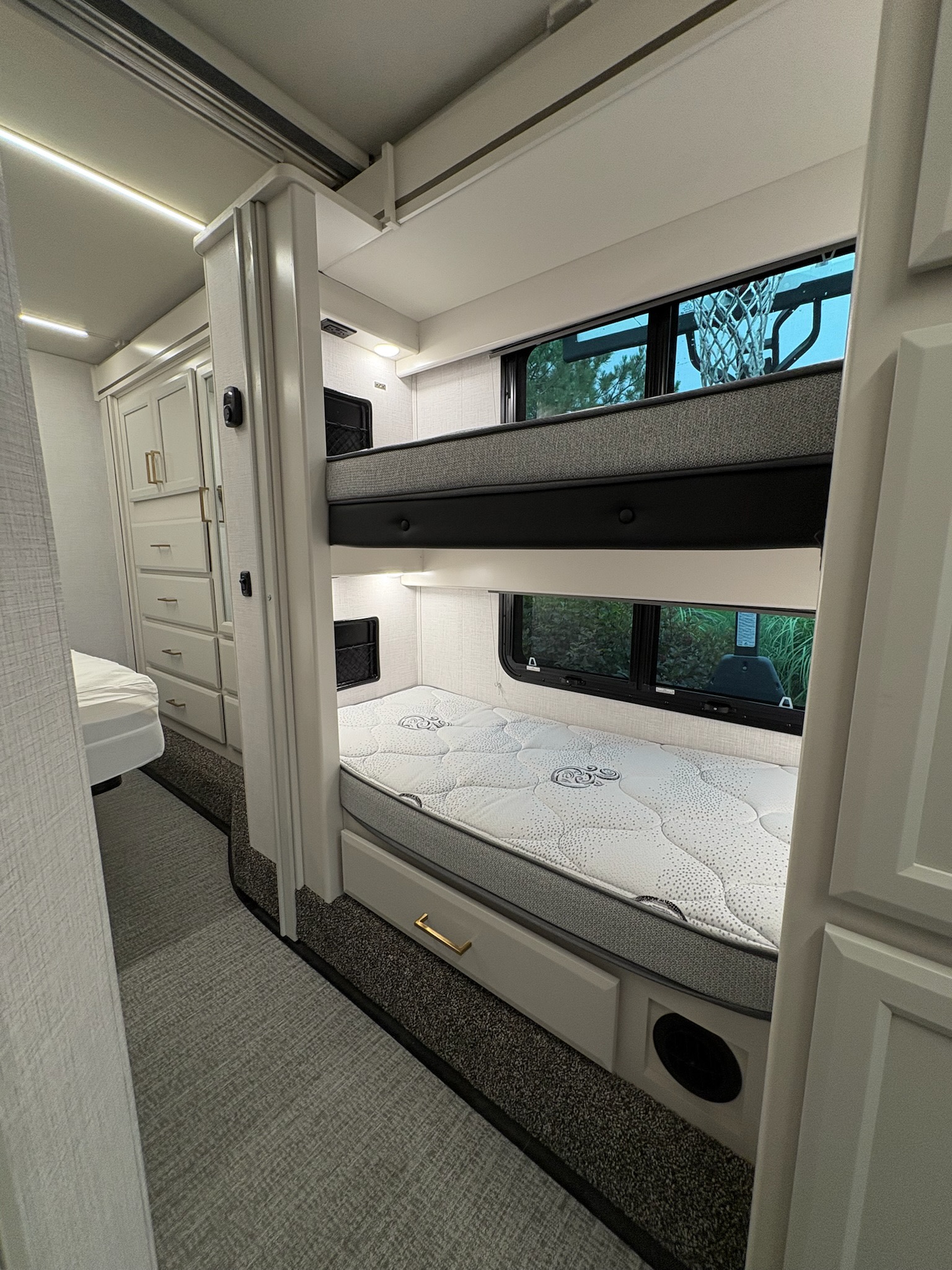 Clean RV rental interior: a bright bunk bed setup with stylish cabinetry & a glimpse of a basketball hoop outside.. Fleetwood Altitude 31W 2026
