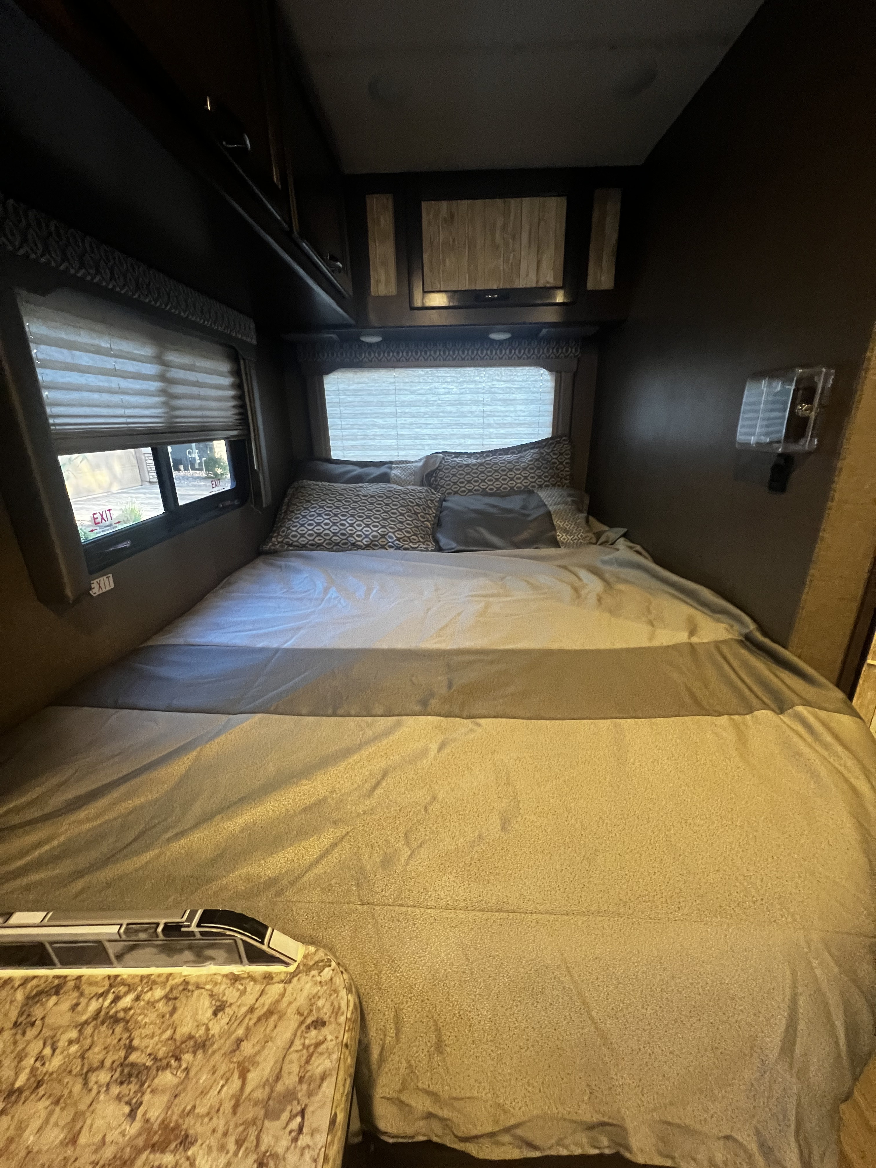 This RV rental bedroom offers a comfortable bed, window views, and convenient overhead storage for travelers.. Thor Freedom Elite 2018