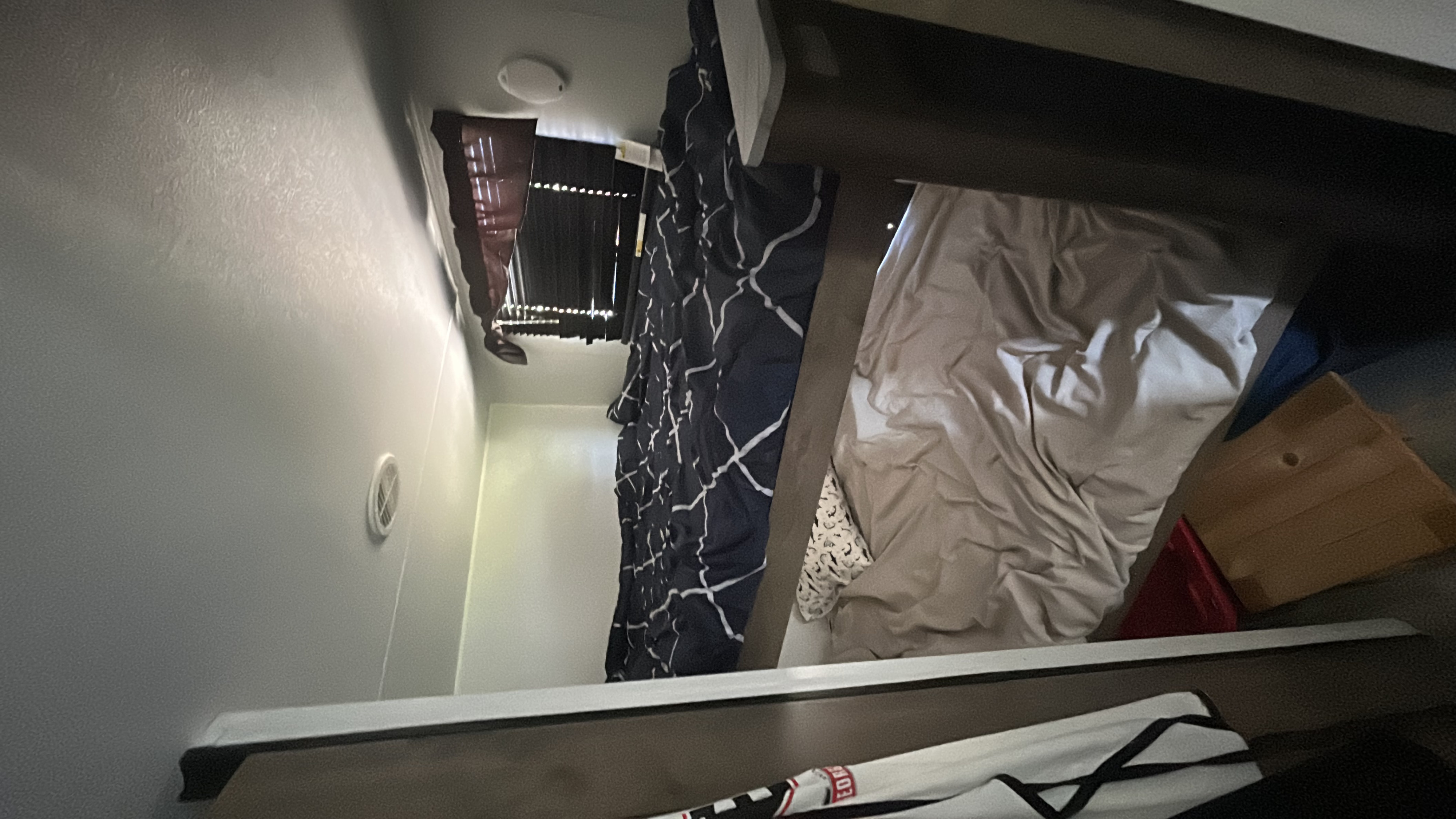 RV rental interior featuring a bunk bed with beige sheets, a patterned curtain, and damaged window blinds or ceiling.. Heartland RVs Pioneer 2024