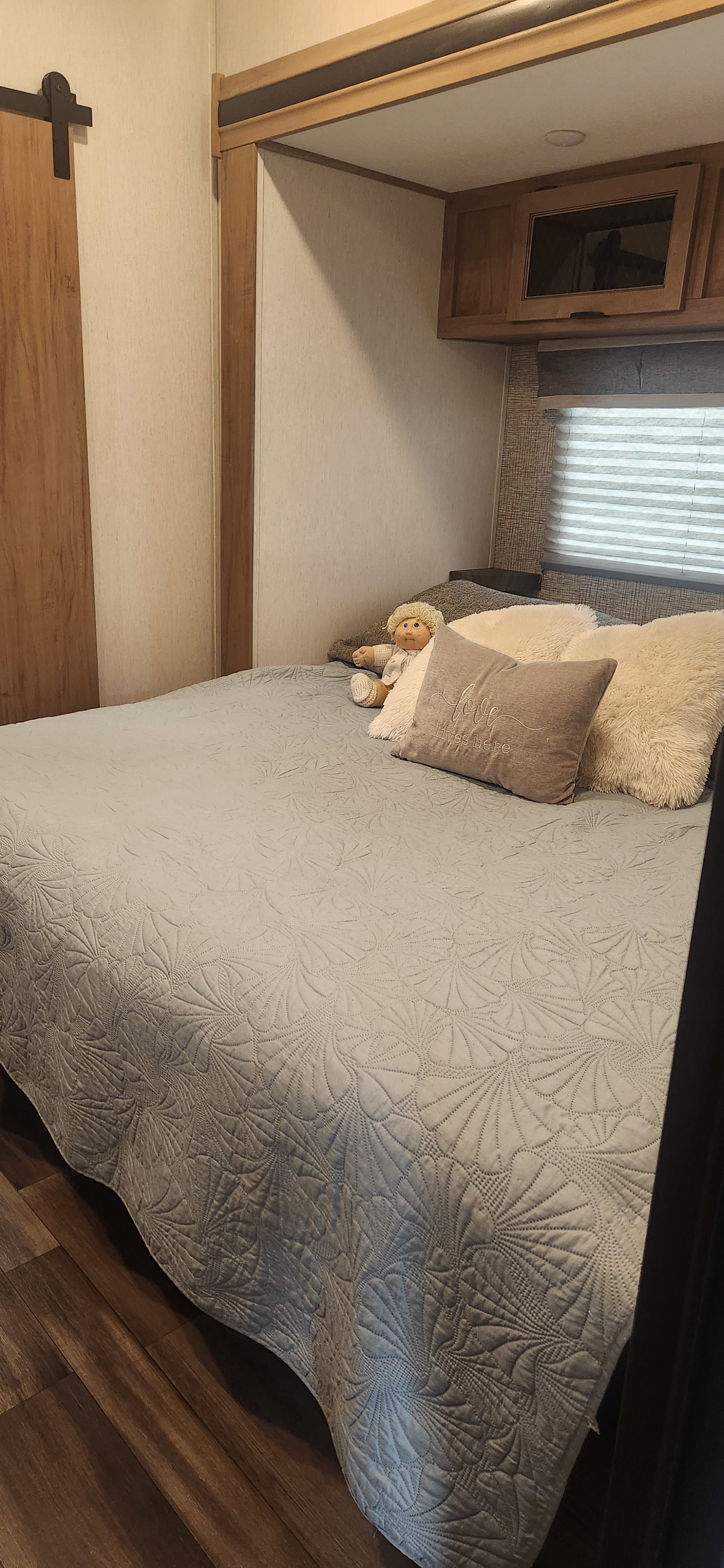 RV rental bathroom with a double vanity, modern fixtures, mirrors, wood flooring, and partial toilet view.. Forest River Sabre 37FLH 2024