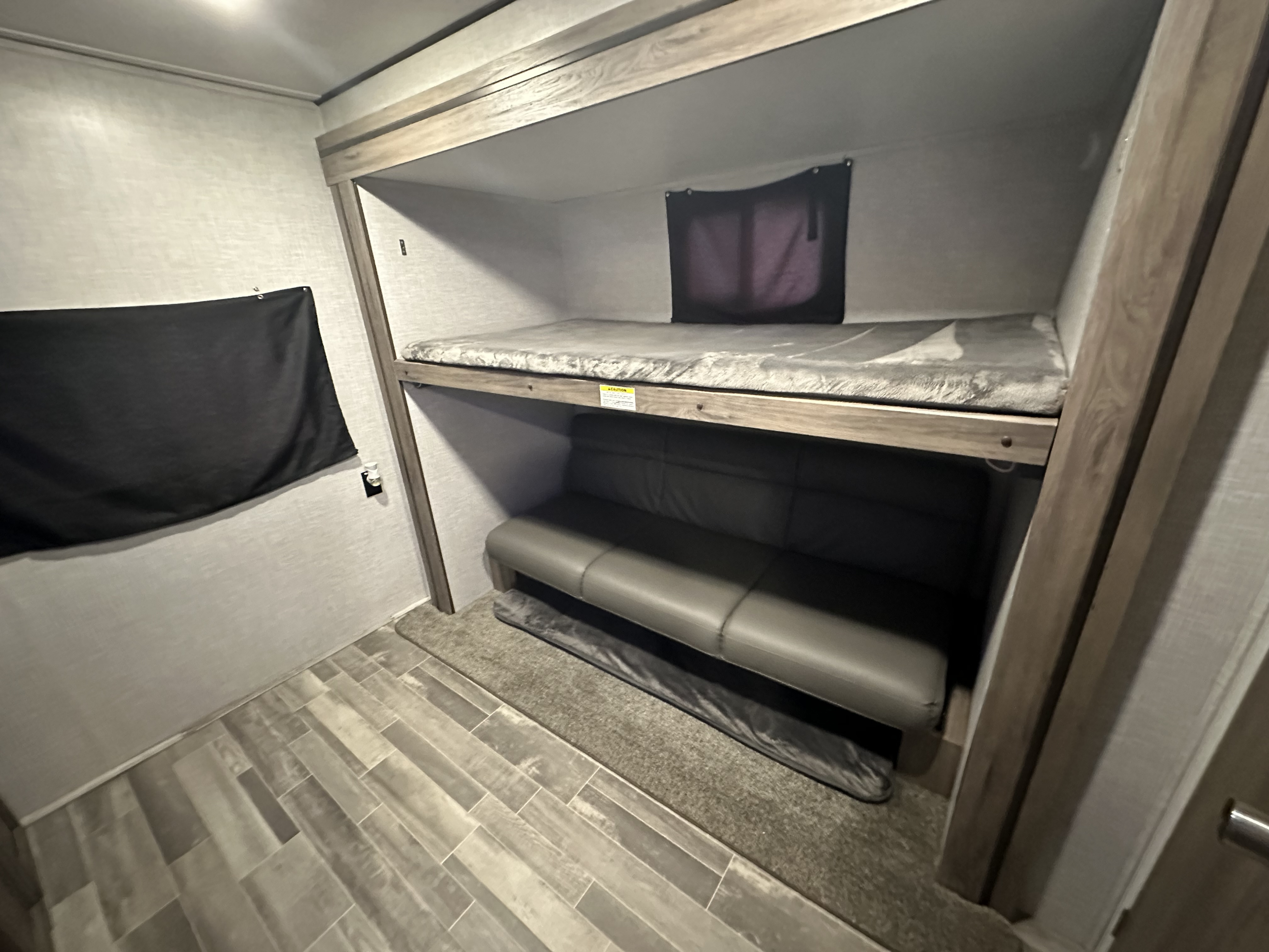 rv rental: Compact bunk beds, lower sofa, and light wood-look interior for cozy travels.. Crossroads RV Zinger 2023