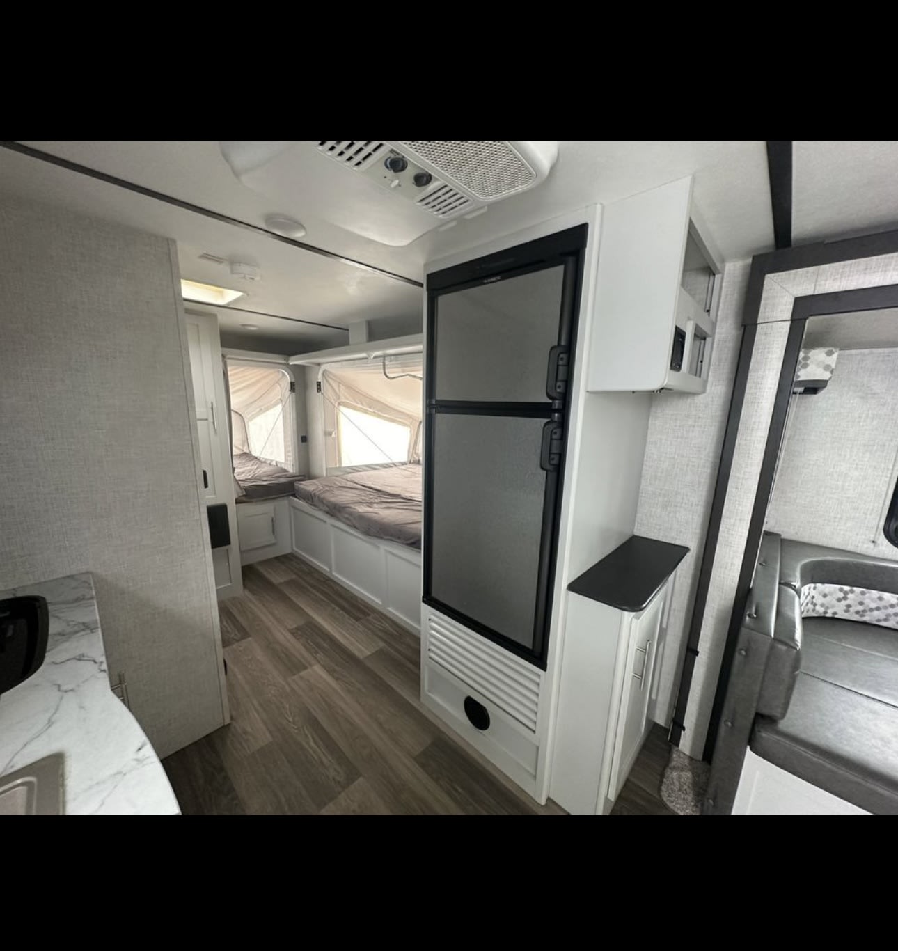 Interior of a modern RV rental, featuring pop-out beds, a refrigerator, and dinette seating. Ready for adventure.. Keystone RV Bullet Crossfire 2020