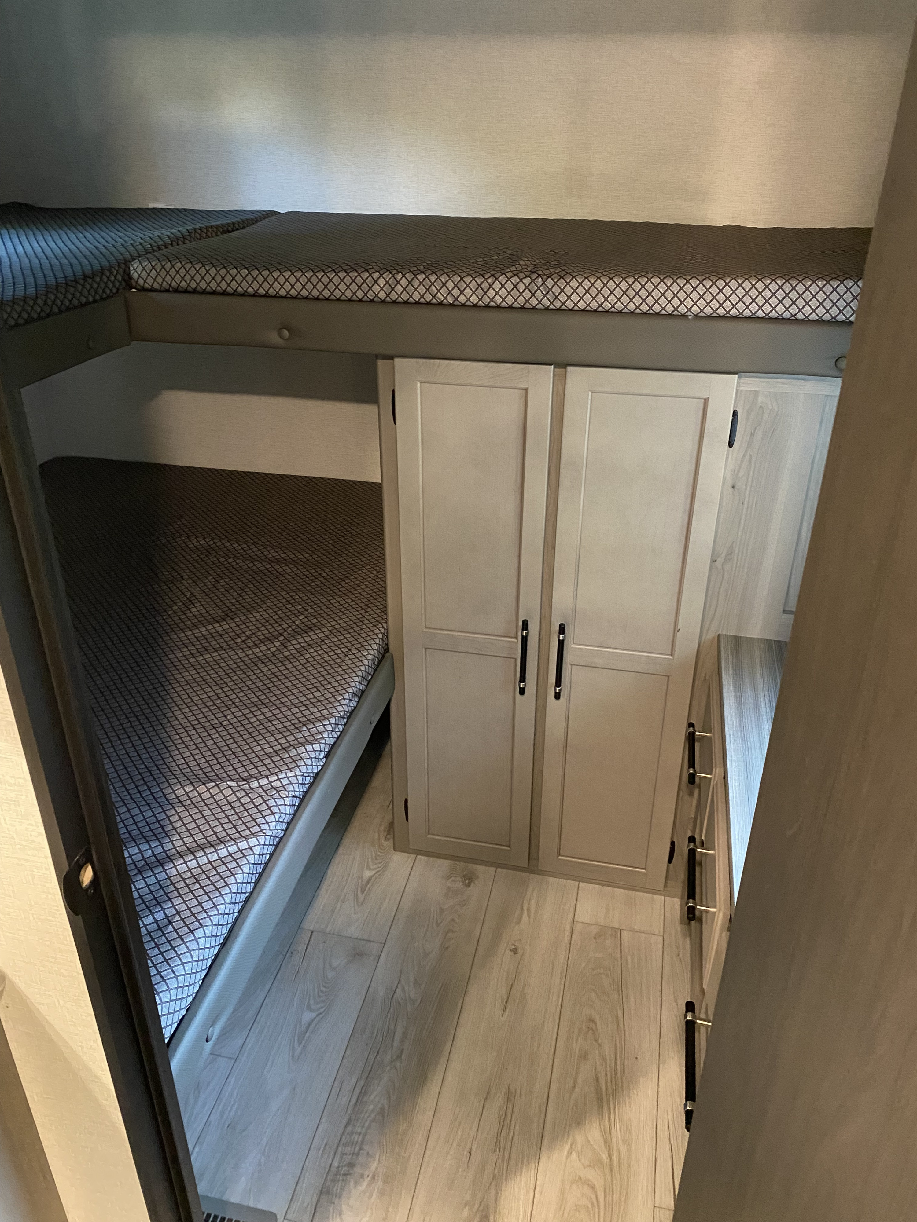 RV rental with modern bunk beds, wardrobe, and dresser. Ideal for family travel, offering compact storage and sleeping space.. Keystone 291BR 2025