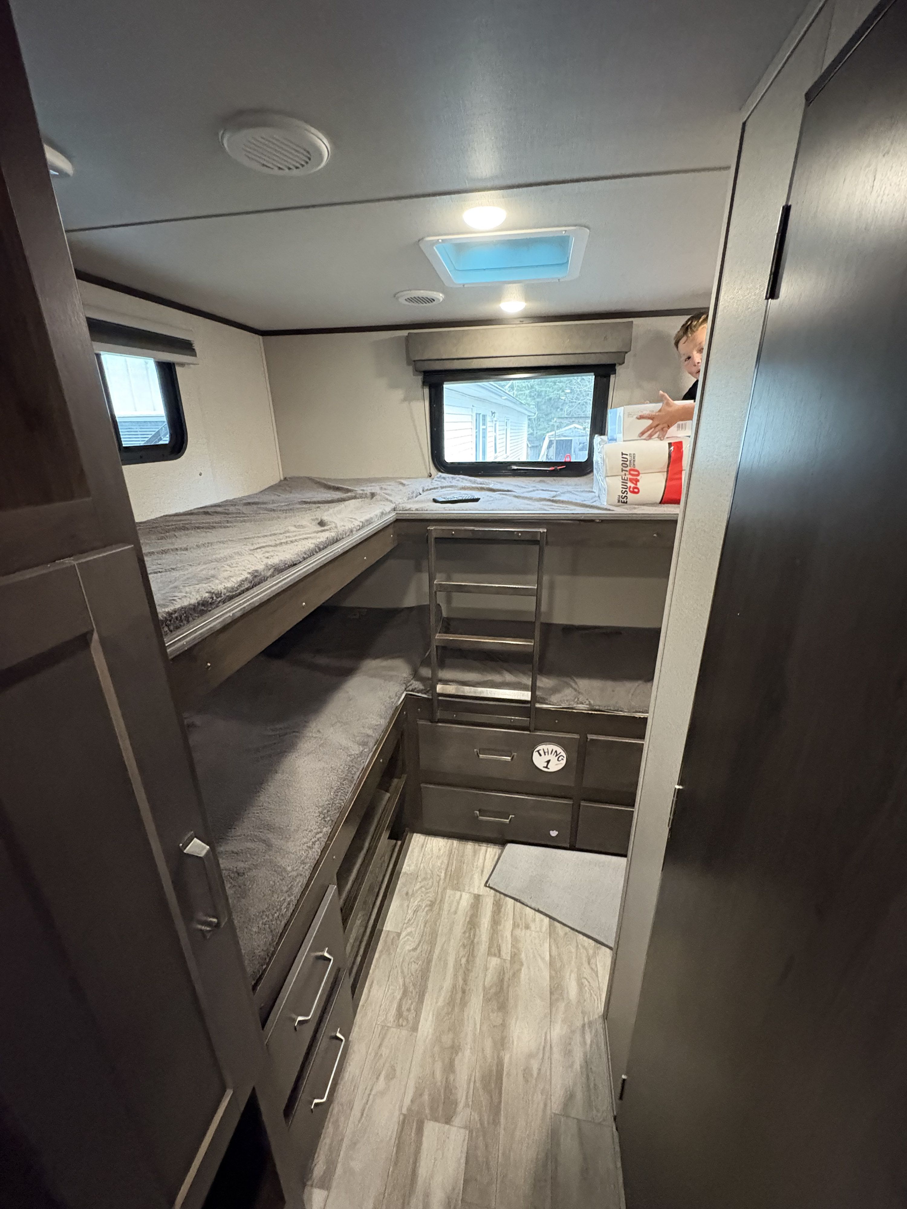 Spacious RV bunkhouse interior featuring multiple beds, ladder, and "THING 1" storage drawers, ideal for your RV rental.. Grand Design Transcend Xplor 2022