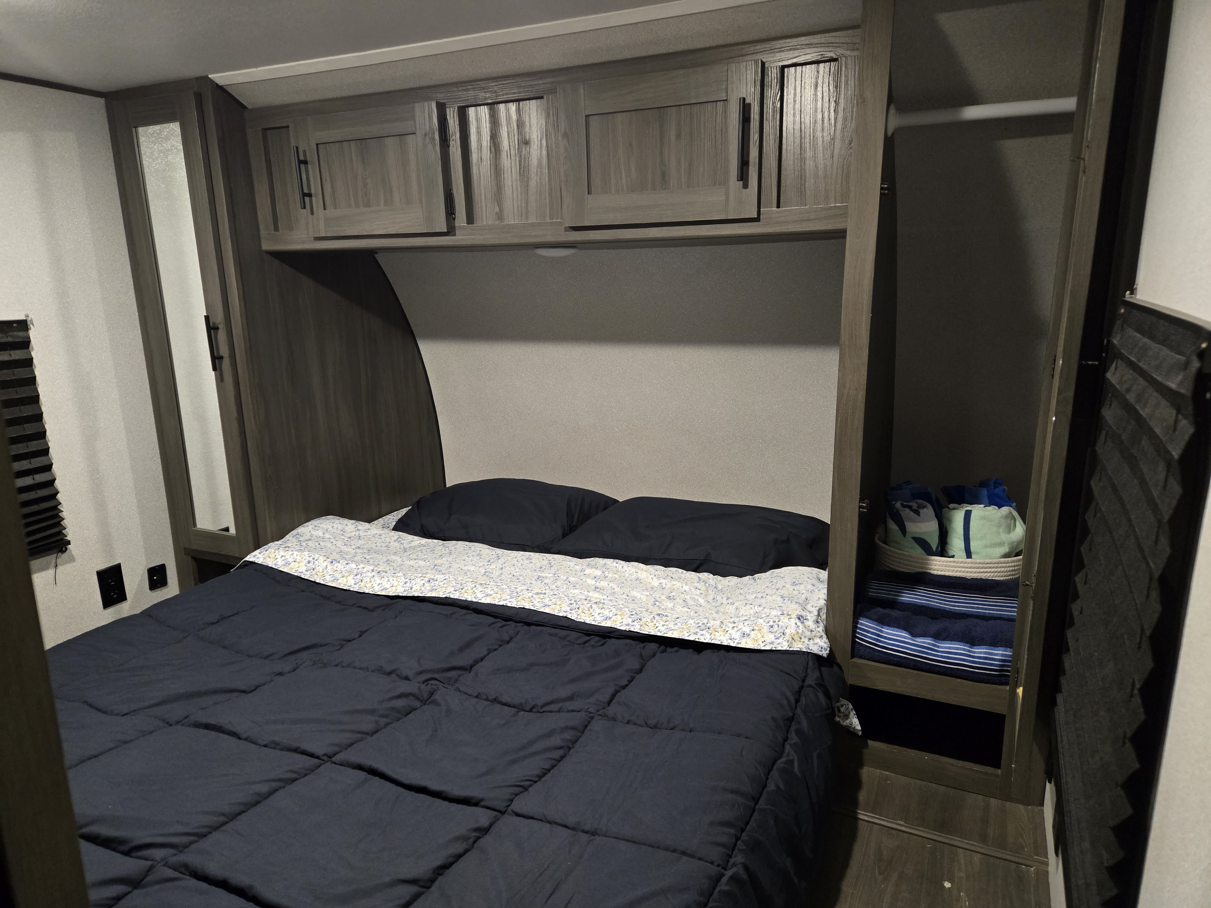 Experience comfortable sleeping in this RV rental bedroom, complete with a cozy bed, ample cabinets, and built-in storage.. Forest River Shasta 2021