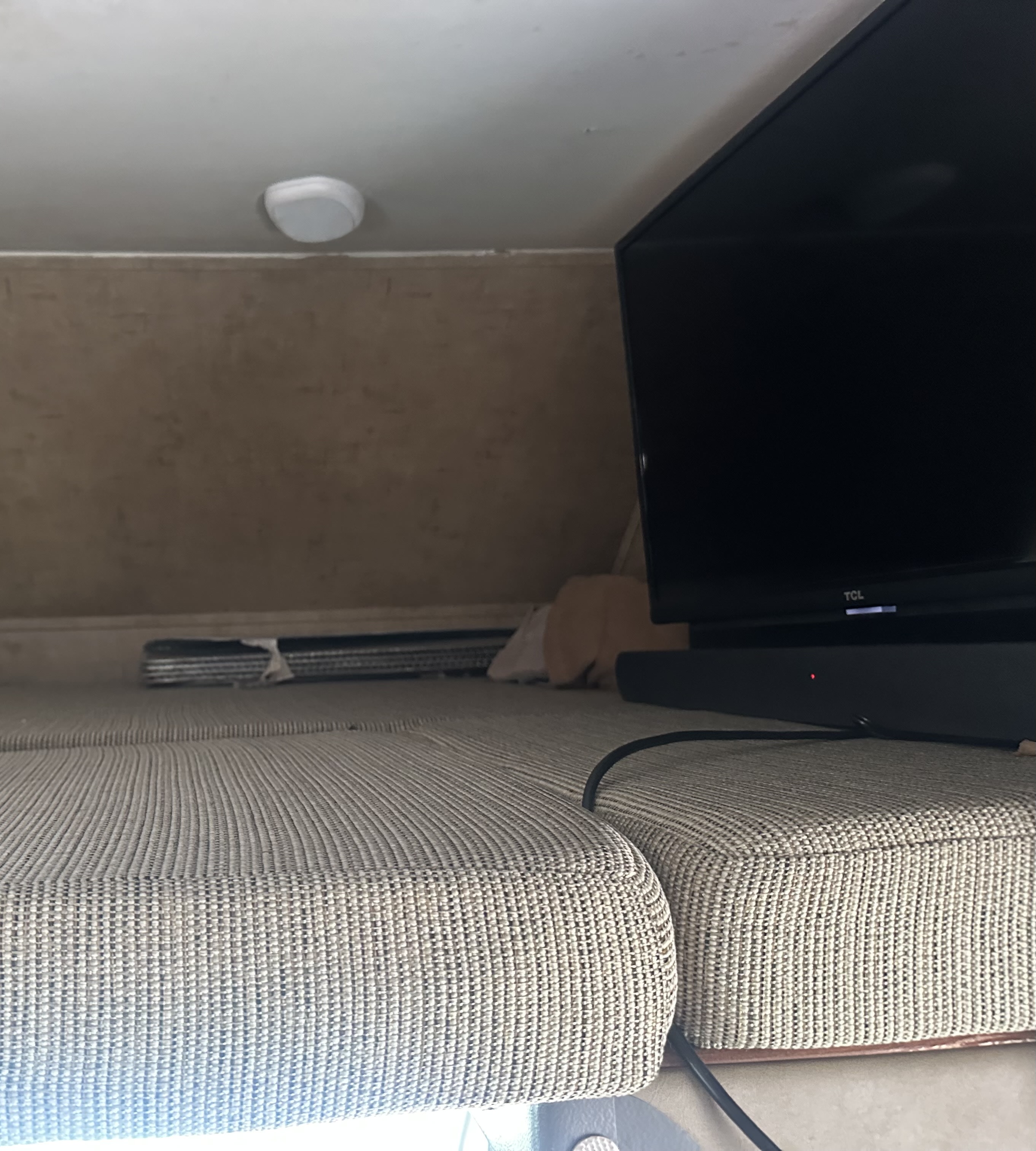 RV rental: Compact seating/bed area with a TV and soundbar, featuring an overhead light.. Forester MBS 2016