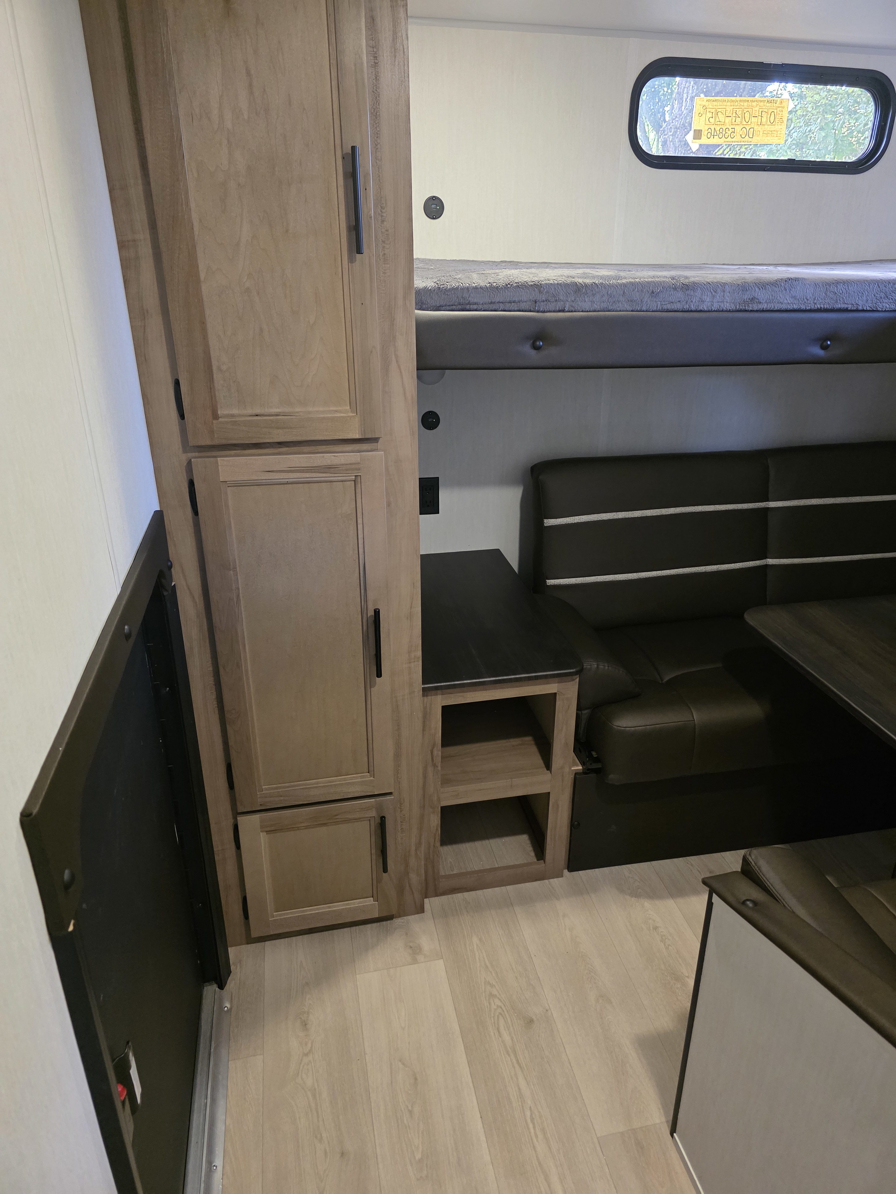 RV rental interior view: bunk beds over a dinette, with wood-look storage cabinets and a bright window.. 4x4tcke22sk092479 Forest River Cherokee 2025