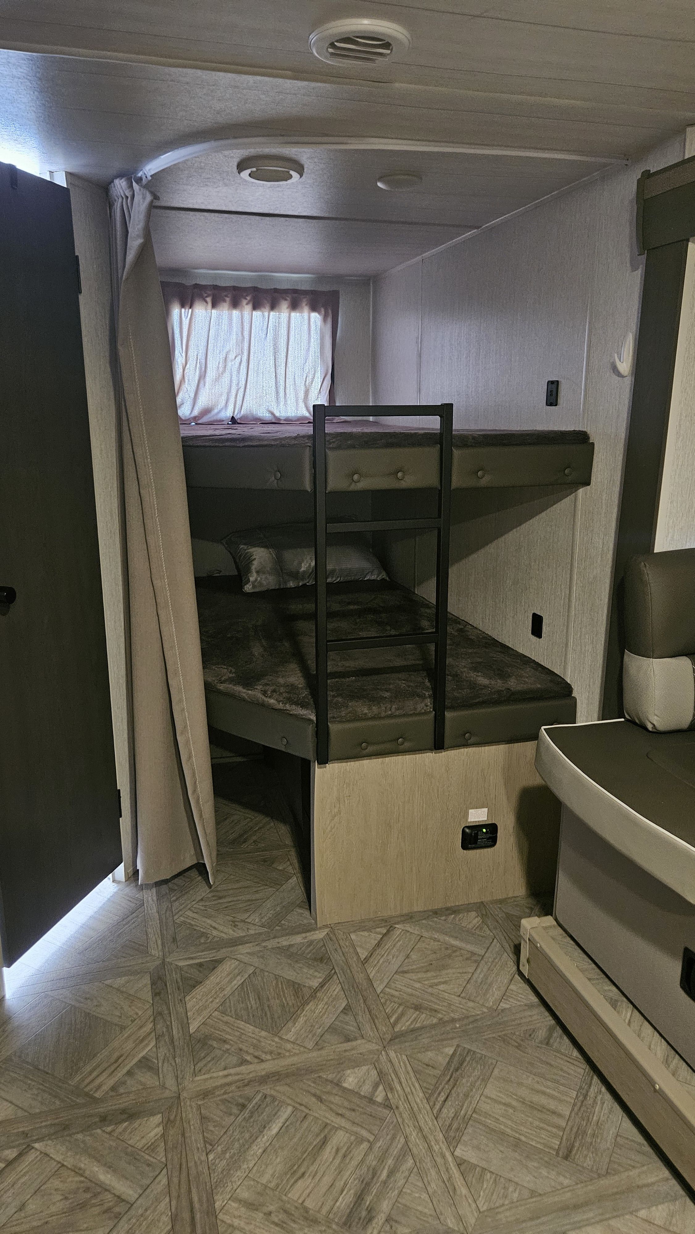 RV rental interior: A compact bunk bed area with a ladder, privacy curtain, and window offers cozy sleeping for travelers.. Forest River Salem Cruise Lite Platinum 2024