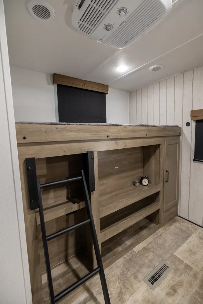 Inside an RV rental: a cozy bunk bed with ladder, built-in storage, and AC for comfortable journeys.. Palomino Puma 2025