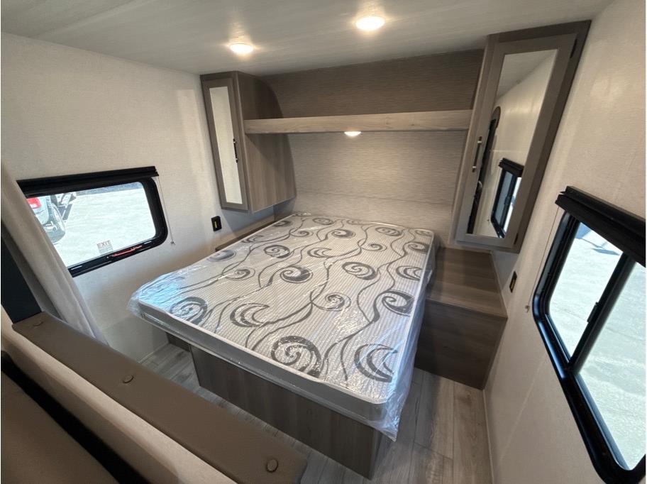 Spacious RV rental bedroom with a new mattress, ample overhead storage, and windows. Modern and clean interior.. Keystone 240Bunkhouse 2025