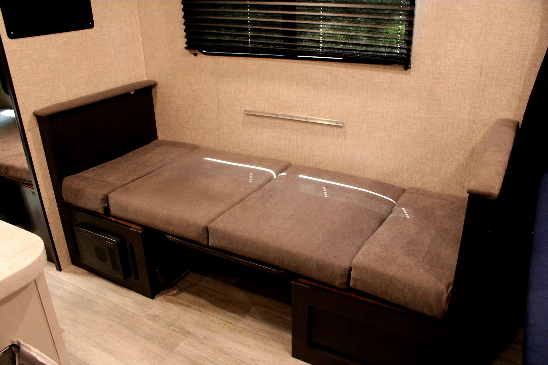 RV rental interior showcasing a comfortable, multi-cushioned bench that converts into a sleeping area.. Jayco Jay Flight 2022