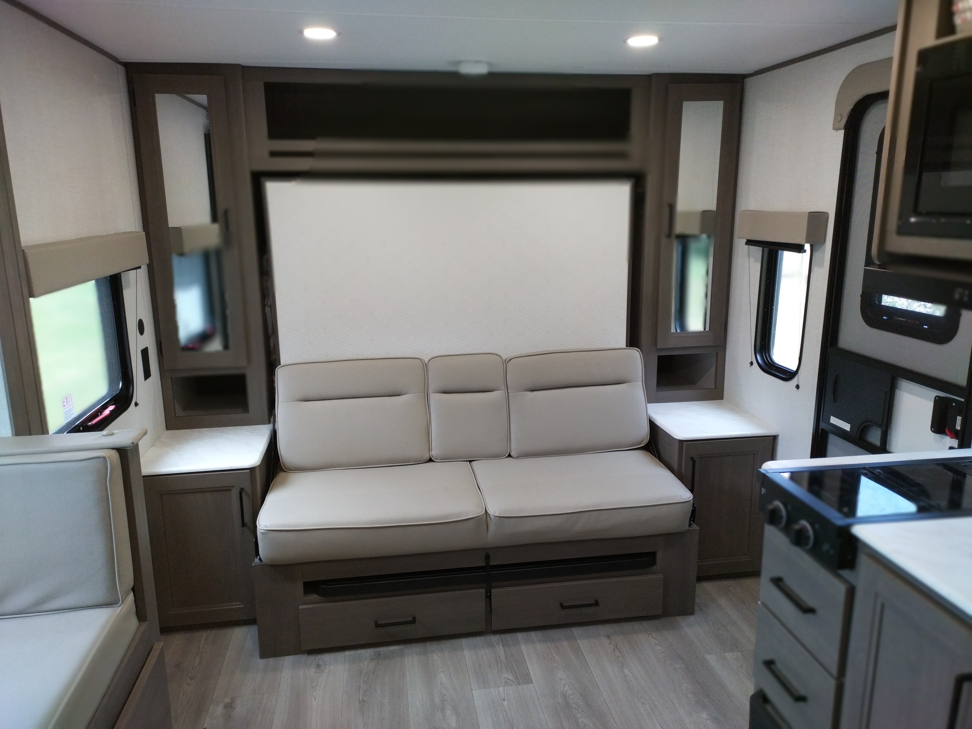 RV rental interior showcasing a comfortable sofa, built-in storage, bright windows, and a modern kitchen area.. Grand Design Transcend One 161BH 2025