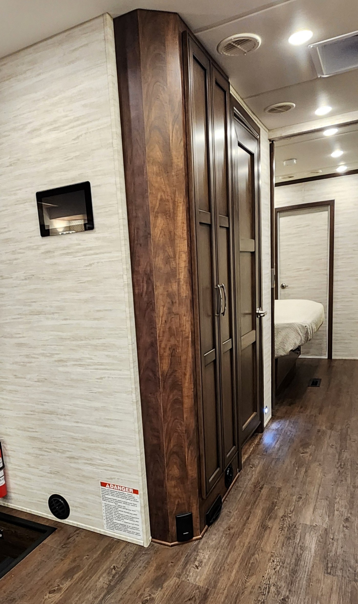 Modern RV rental interior showcasing a hallway, wood-look flooring, light walls, and dark storage cabinetry leading to a bedroom.. Newmar Canyon Star 2024