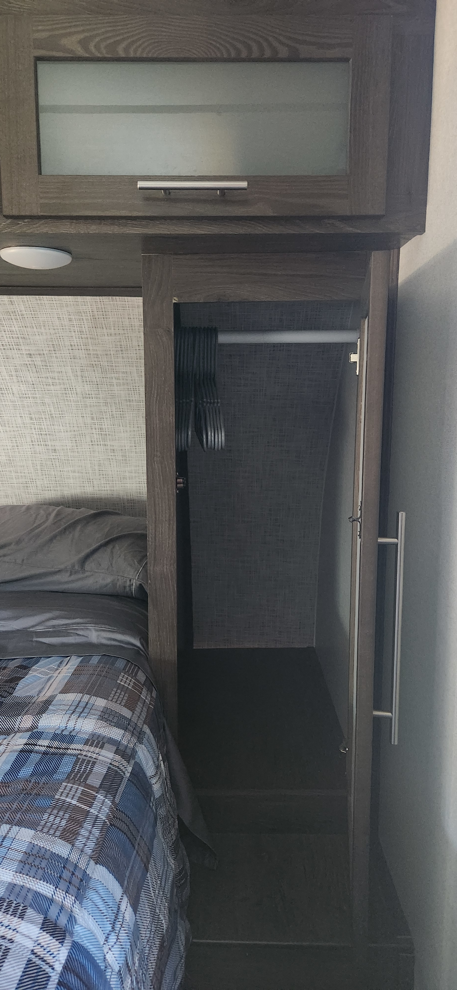 RV rental: Modern bedroom featuring dark wood overhead cabinet, open closet with hangers, and a cozy plaid bed.. Forest River Salem Hemisphere Lite 2019