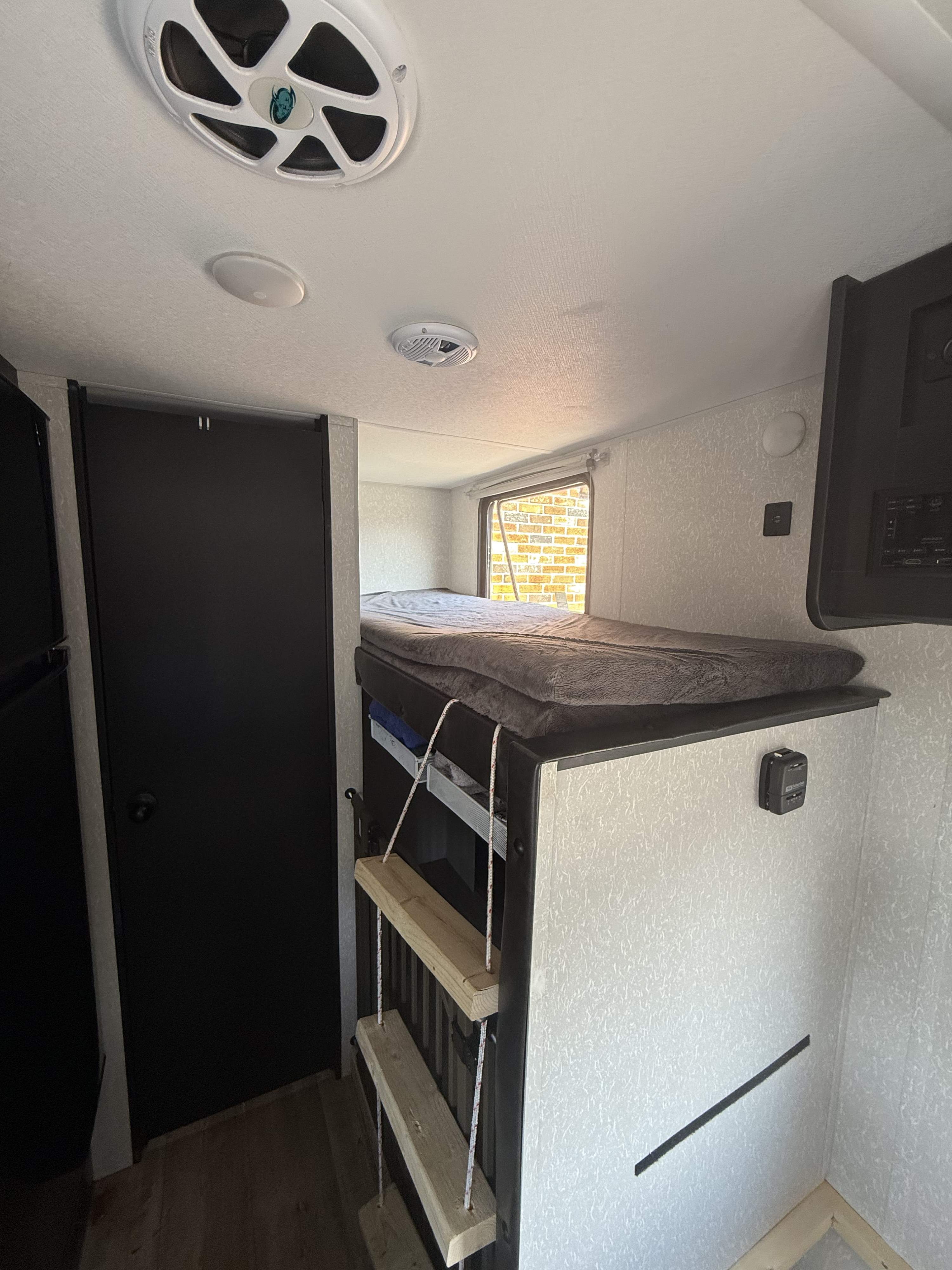 Experience comfort in this RV rental! View of the bunk beds, custom ladder, window, and integrated tech like speakers.. Forest River Cherokee Wolf Pup 2022