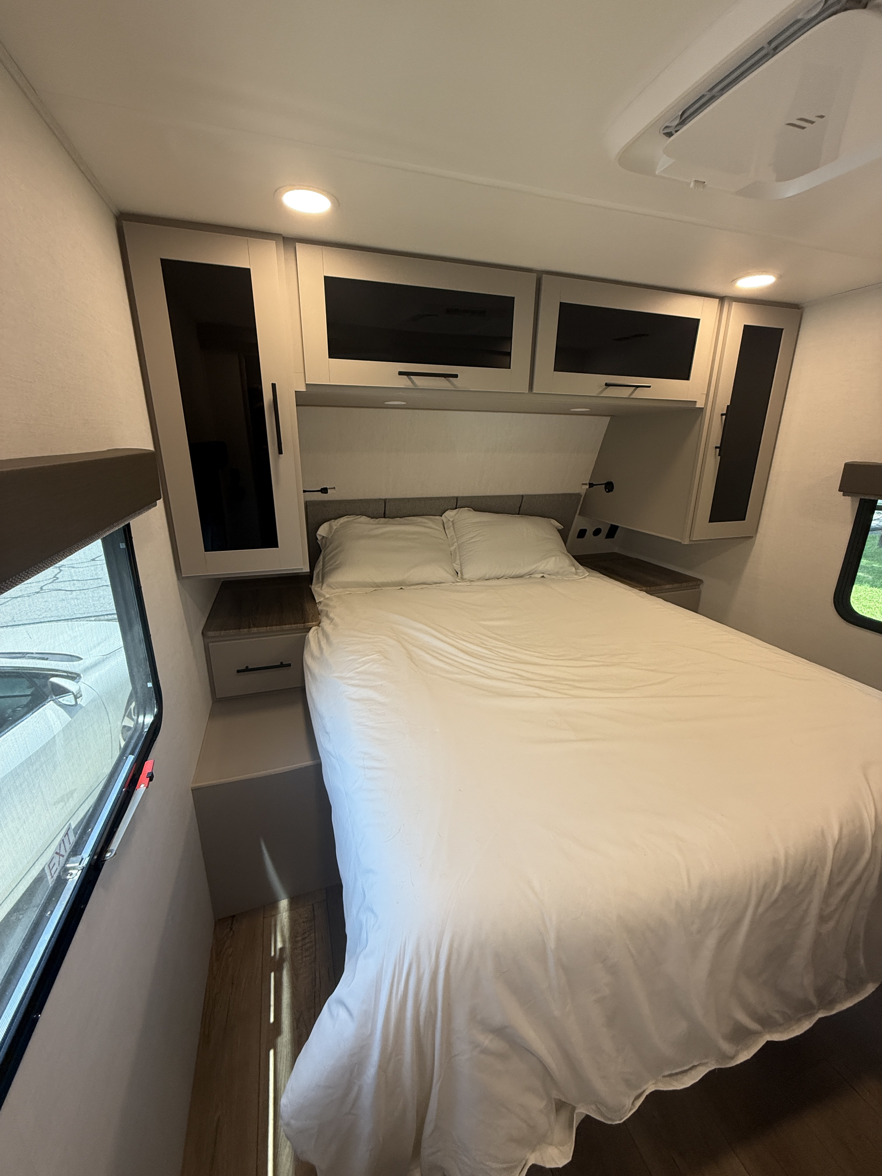Cozy RV rental bedroom with a queen bed, bright lighting, overhead storage, and efficient design for your travels.. Alliance Delta 2026