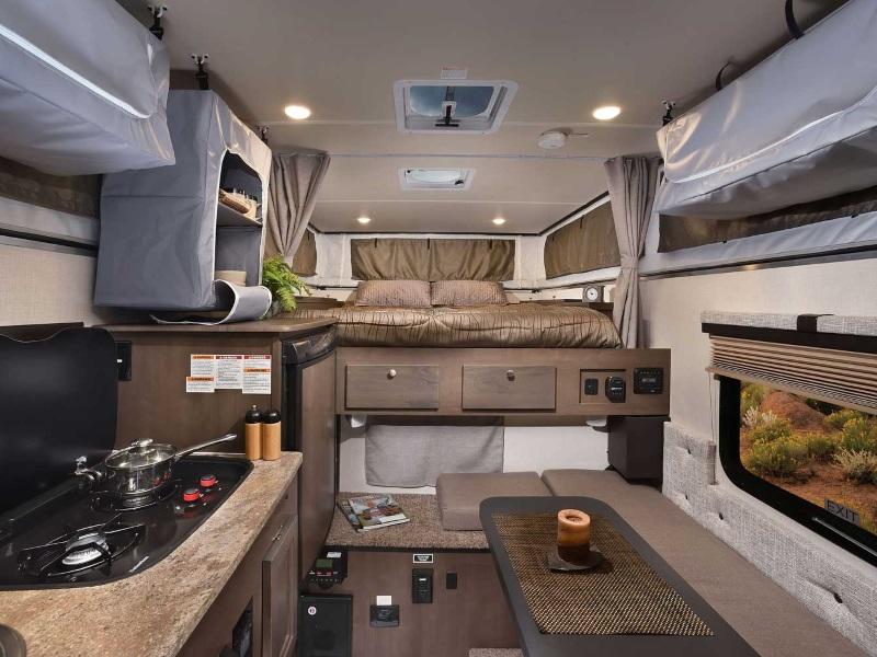RV rental interior: A compact mobile living space featuring a bed, kitchen, dining area, and overhead storage.. Palomino Backpack Edition 2018