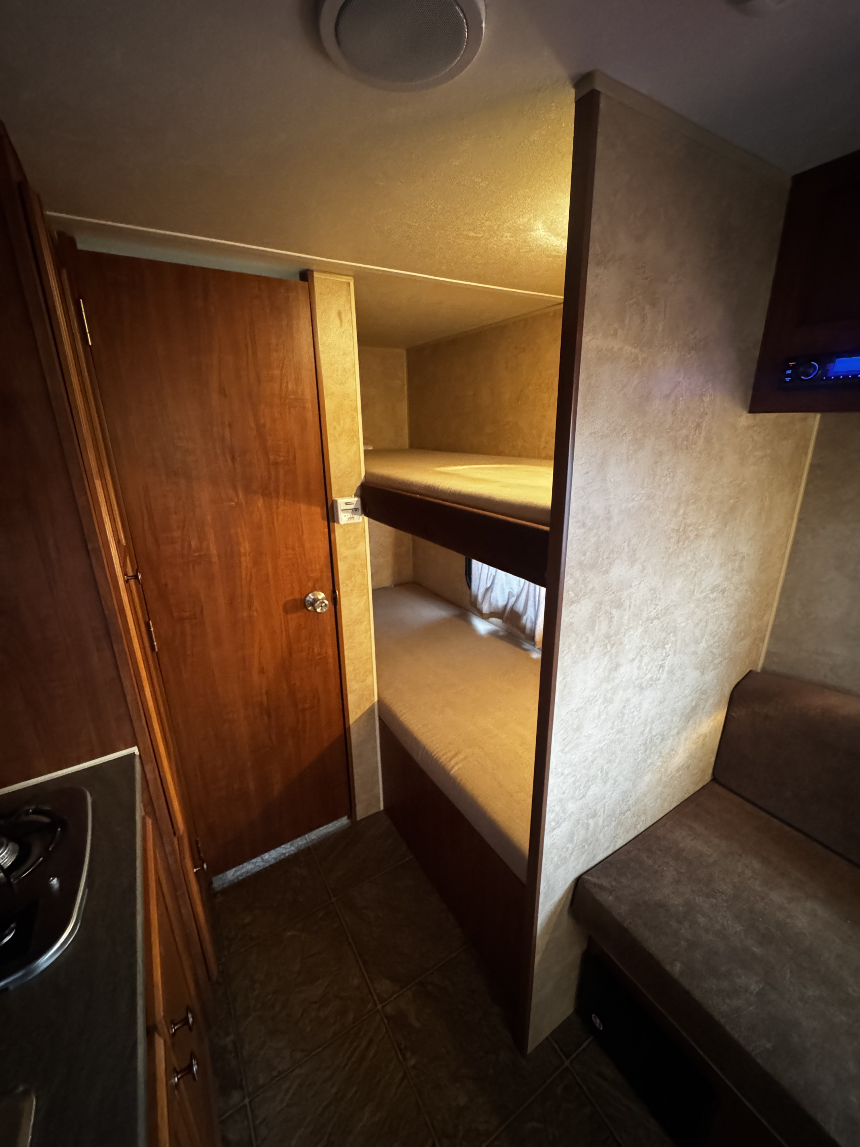 RV rental interior with bunk beds, kitchen area, door, sofa seating, and media center.. Jayco Jay Flight Swift SLX 2012